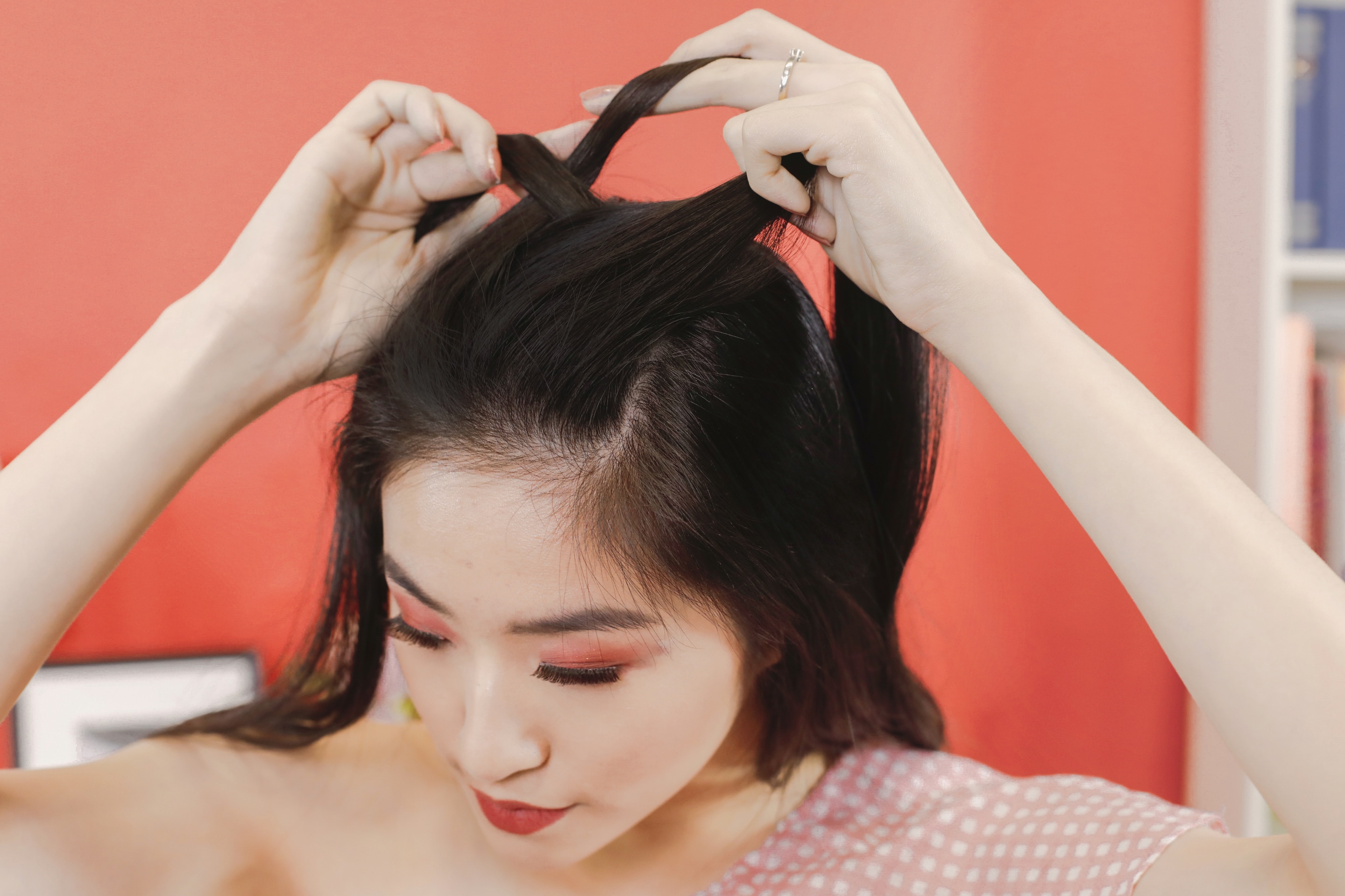 ผู้หญิงเอเชียผมยาวสีดำ กำลังถักเปียฝรั่งเศส