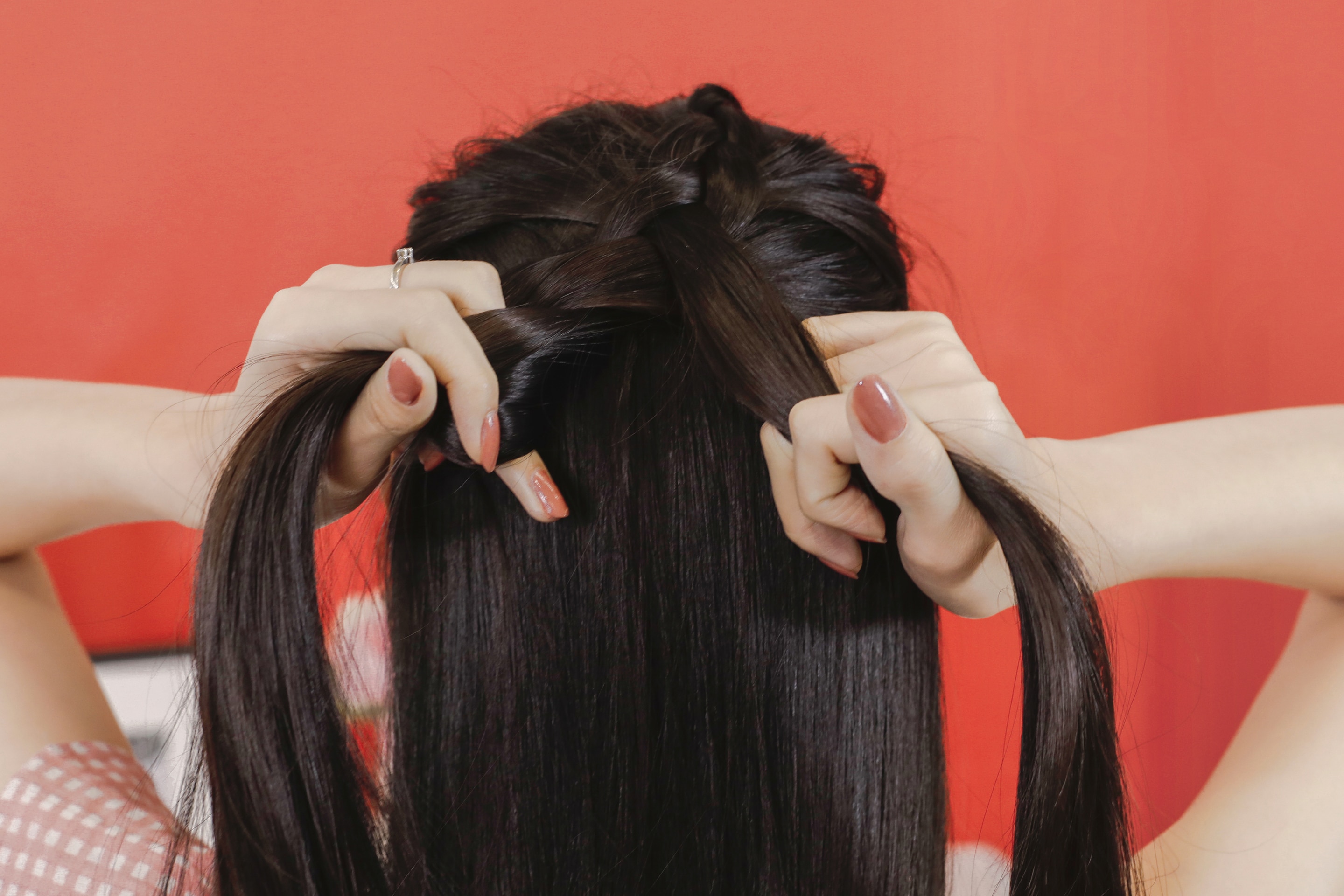 ผู้หญิงเอเชียผมยาวสีดำ กำลังถักเปียฝรั่งเศส