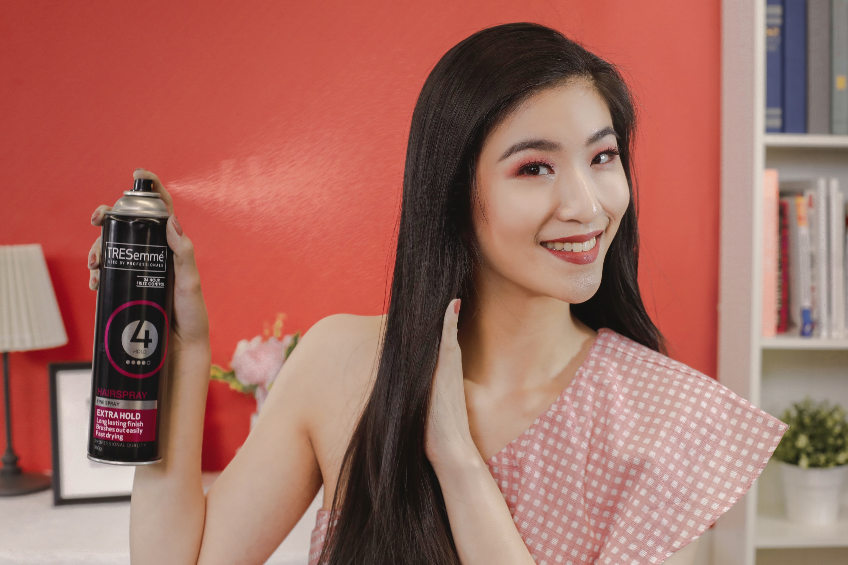 ผู้หญิงเอเชียผมยาวสีดำ กำลังฉีดสเปรย์