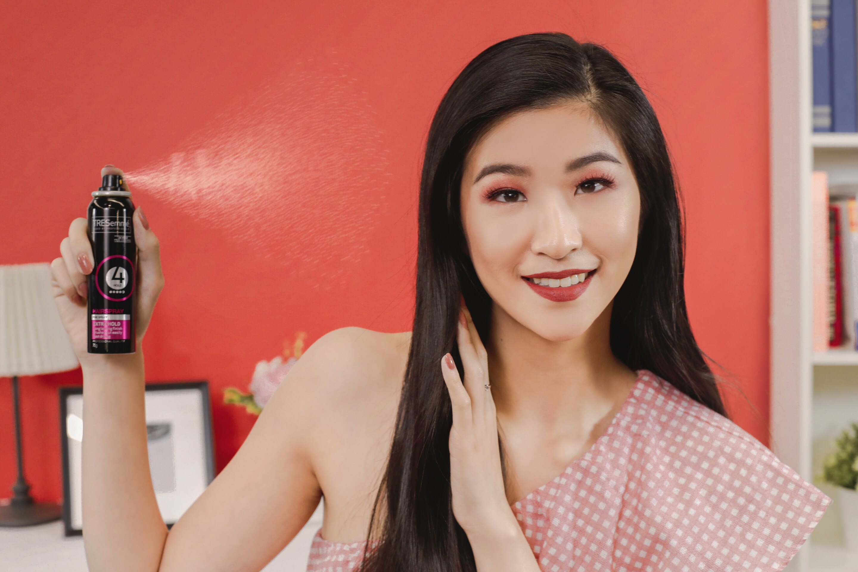 ผู้หญิงเอเชียผมยาวสีดำ กำลังฉีดสเปรย์