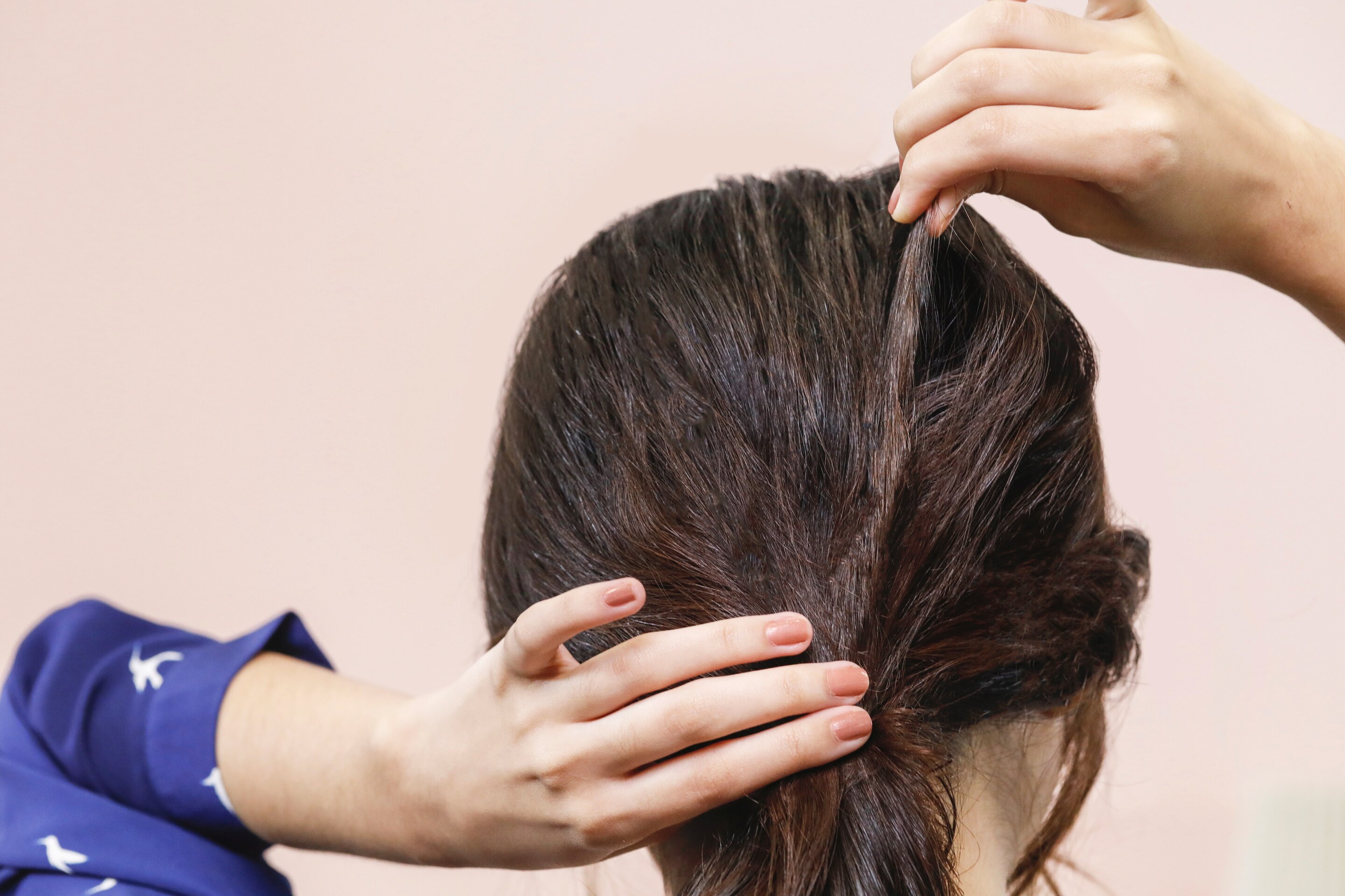 ผู้หญิงเอเชียผมยาวสีดำ กำลังดึงผม เพื่อเพิ่มวอลุ่ม