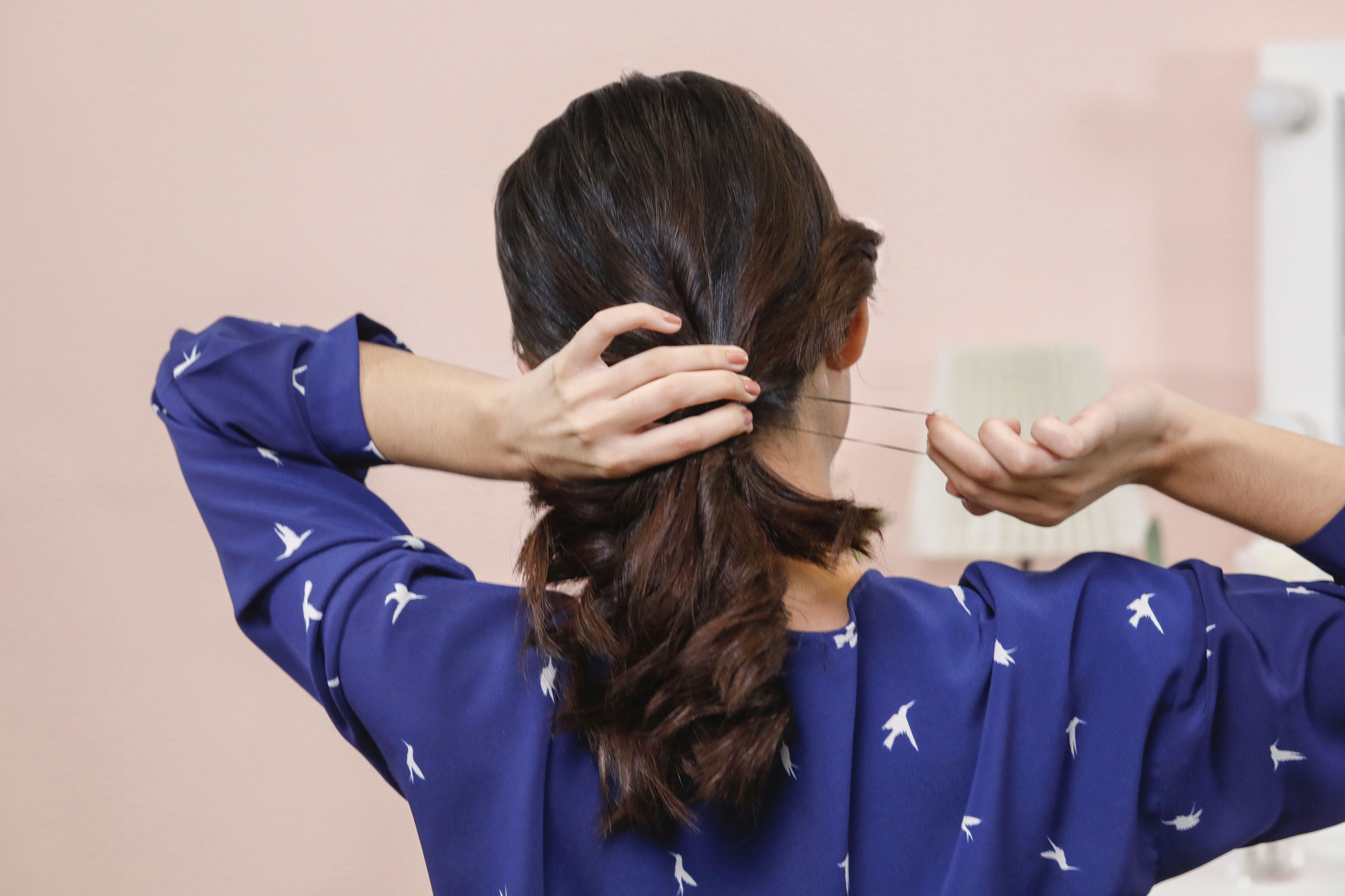 ผู้หญิงเอเชียผมยาวสีดำ กำลังมัดผมหางม้า