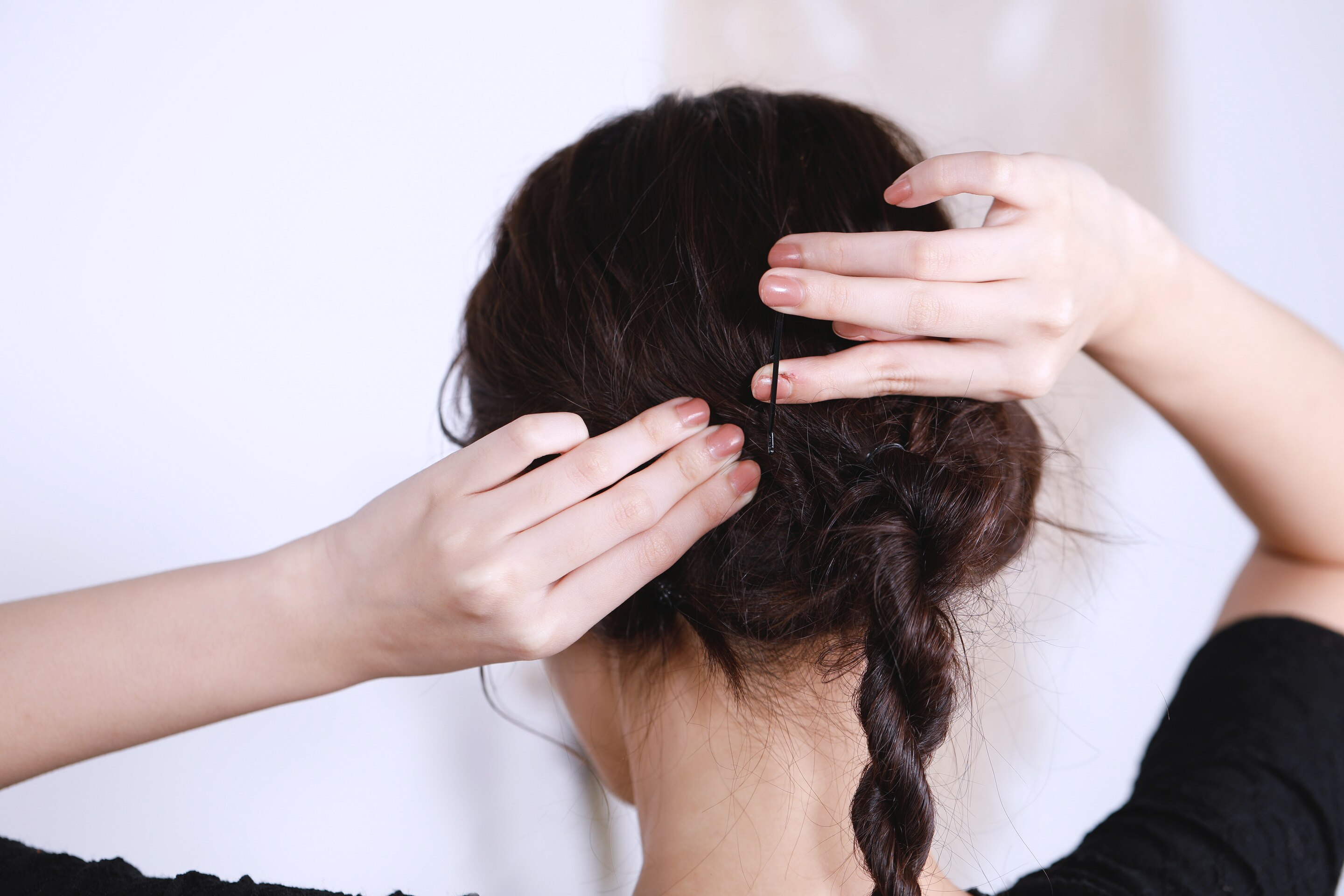 ผู้หญิงเอเชียผมยาวสีดำ กำลังเกล้าผม