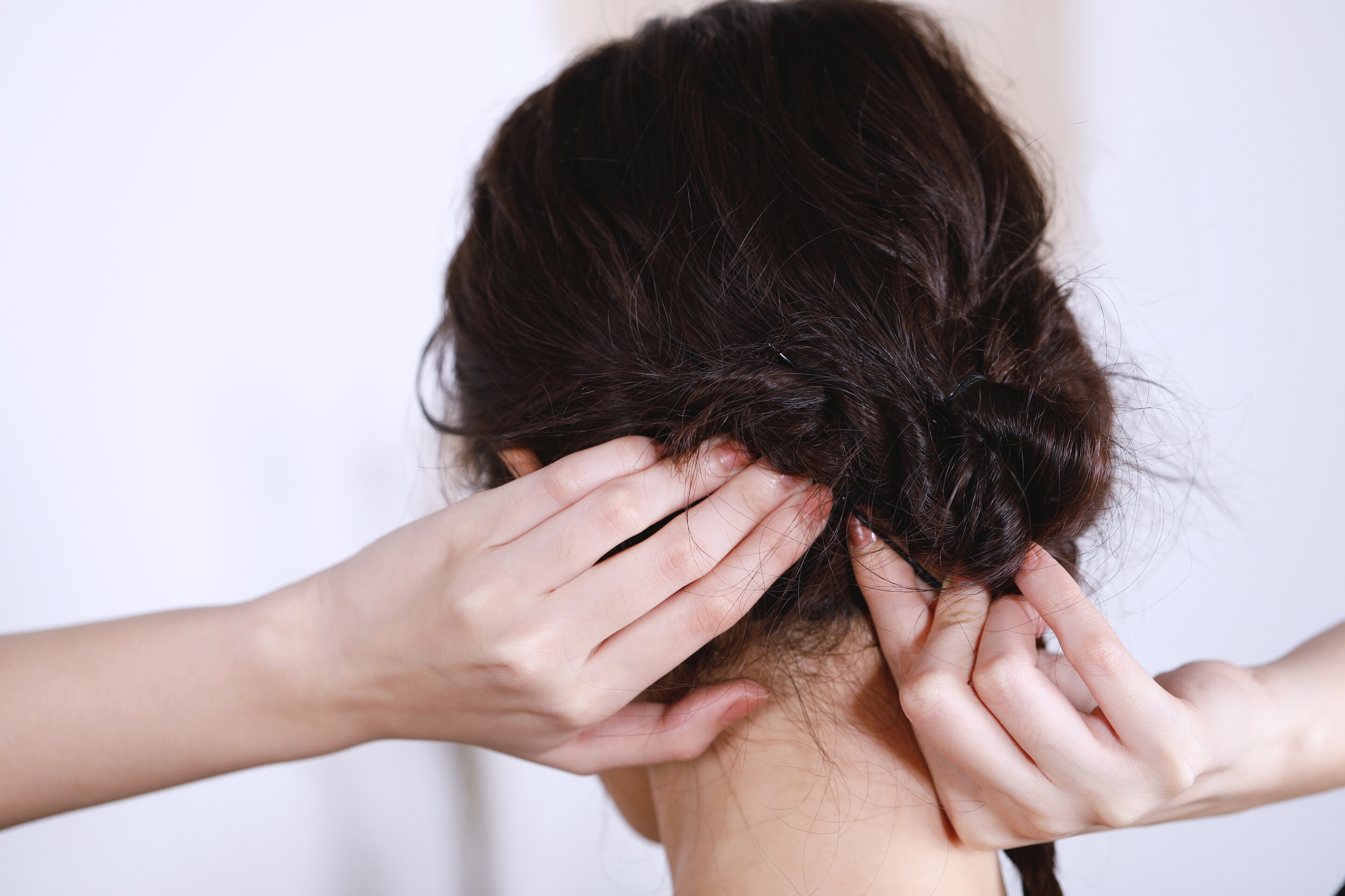 ผู้หญิงเอเชียผมยาวสีดำ กำลังเกล้าผม