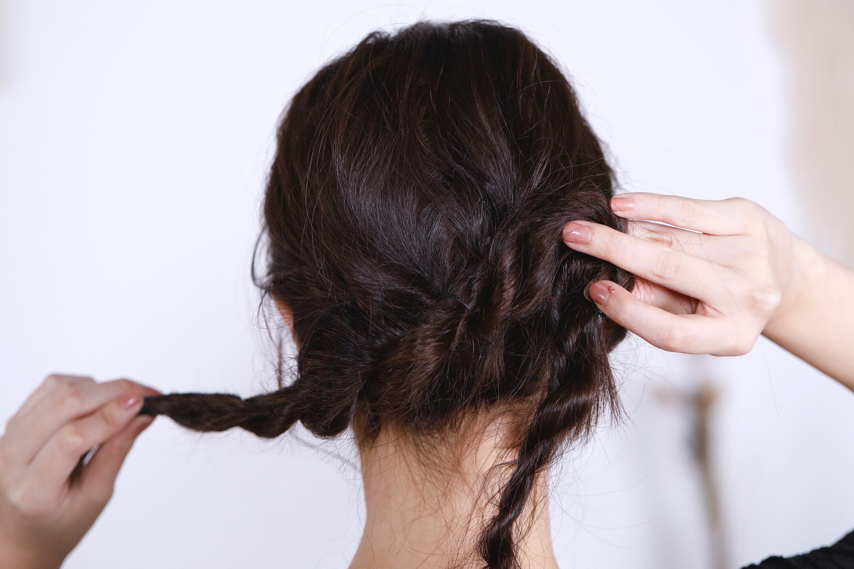 ผู้หญิงเอเชียผมยาวสีดำ กำลังเกล้าผม