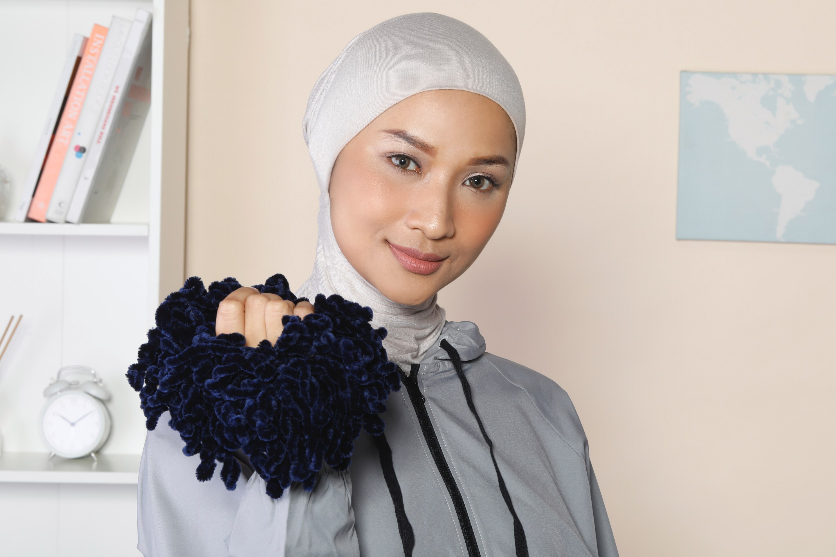 Wanita Asia memakai ciput ninja dan memegang scrunchie