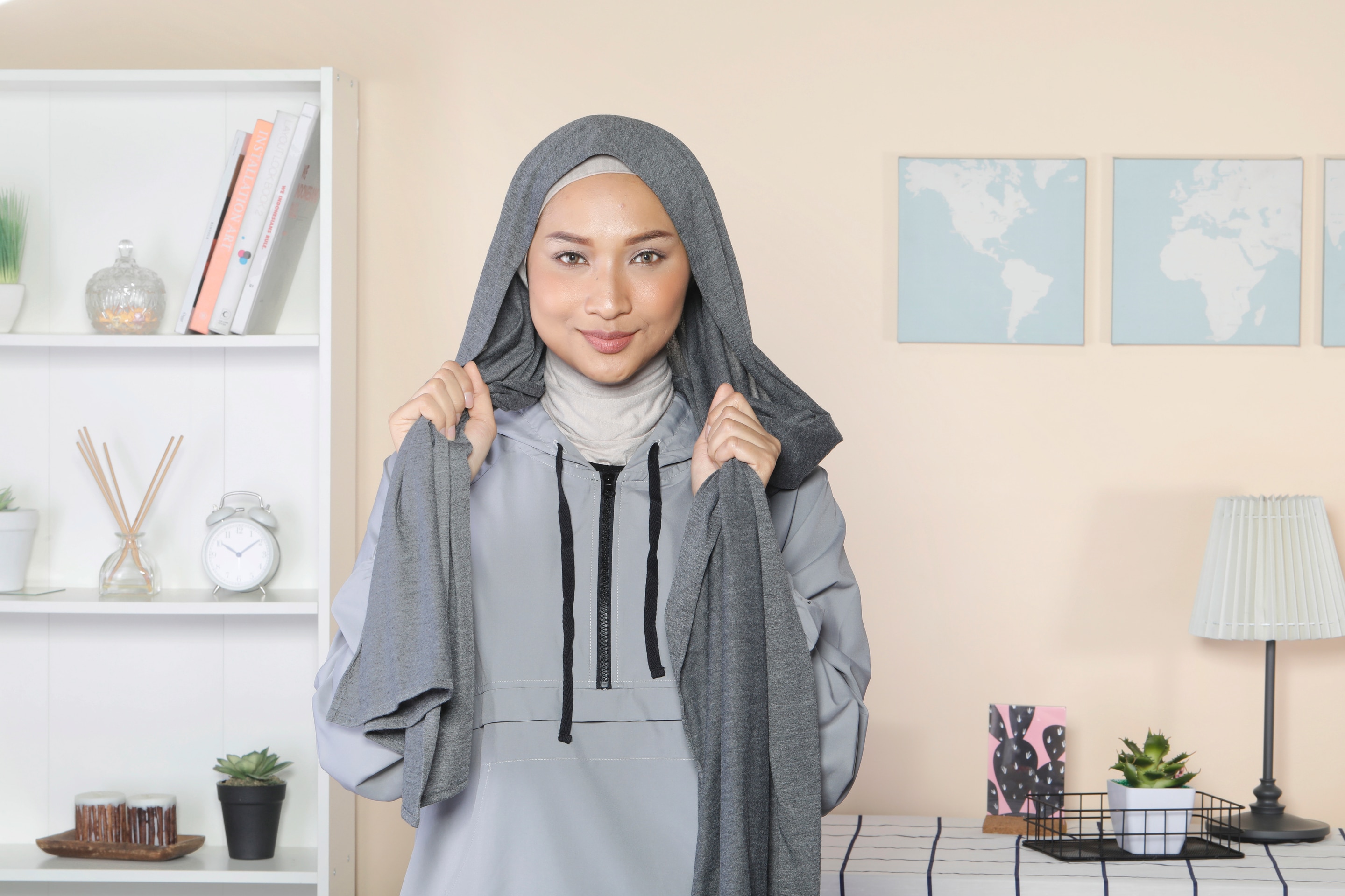 Wanita Asia memakai pashmina dan menunjukkan satu sisi lebih panjang dari sisi lainnya