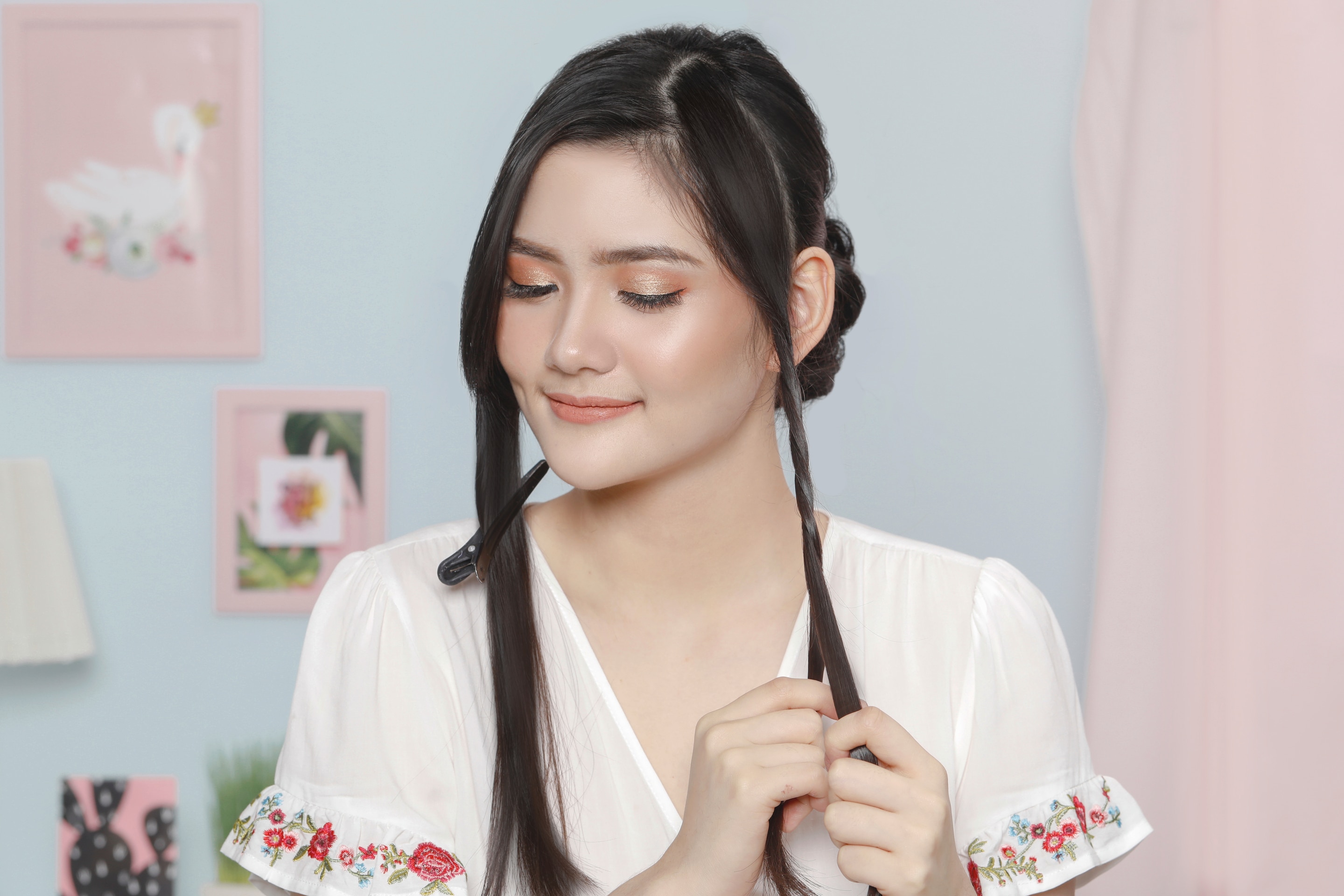 Wanita asia sedang membuat twist pada bagian samping wajah