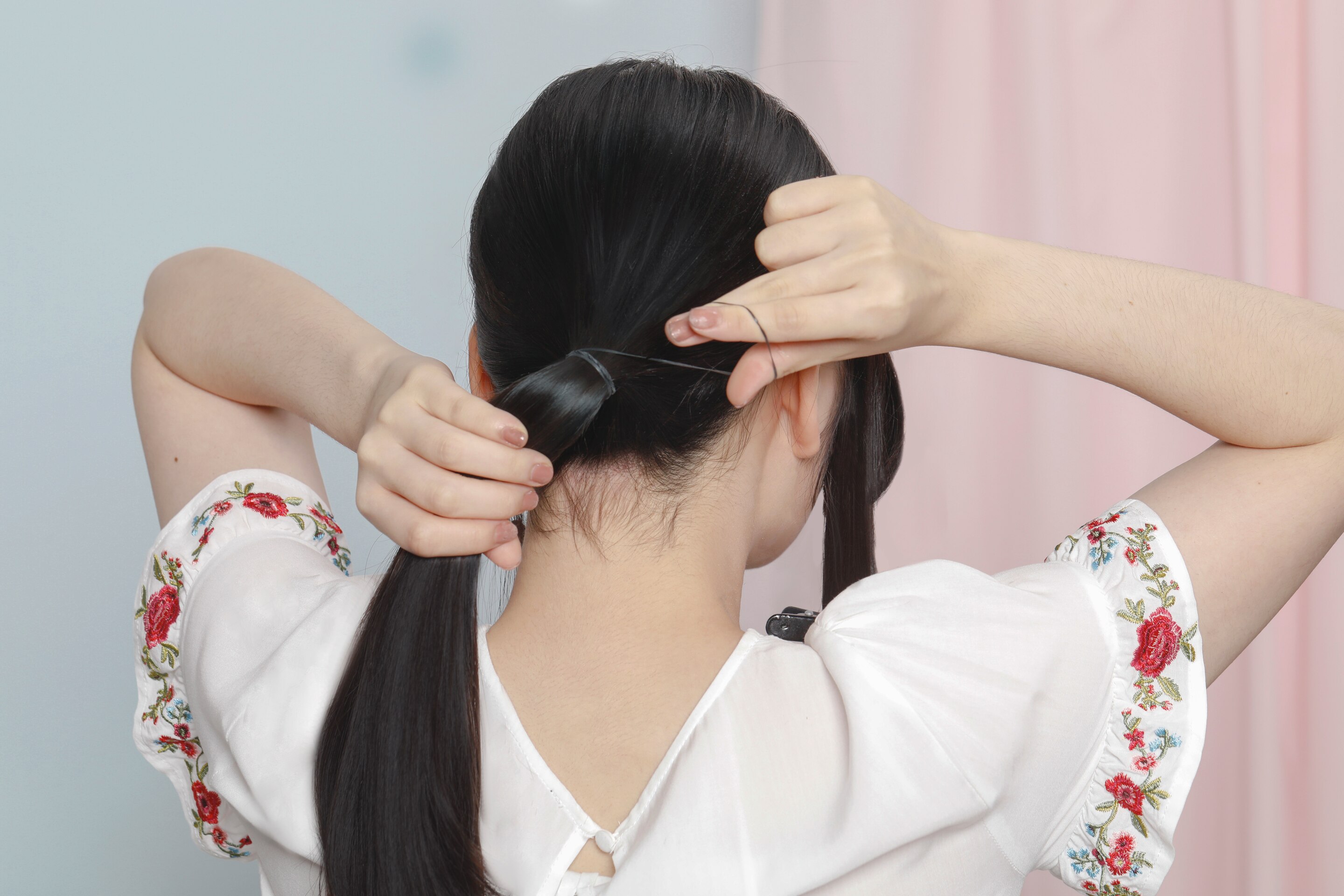 Wanita asia sedang Membuat ponytail pada sanggul twist panjang