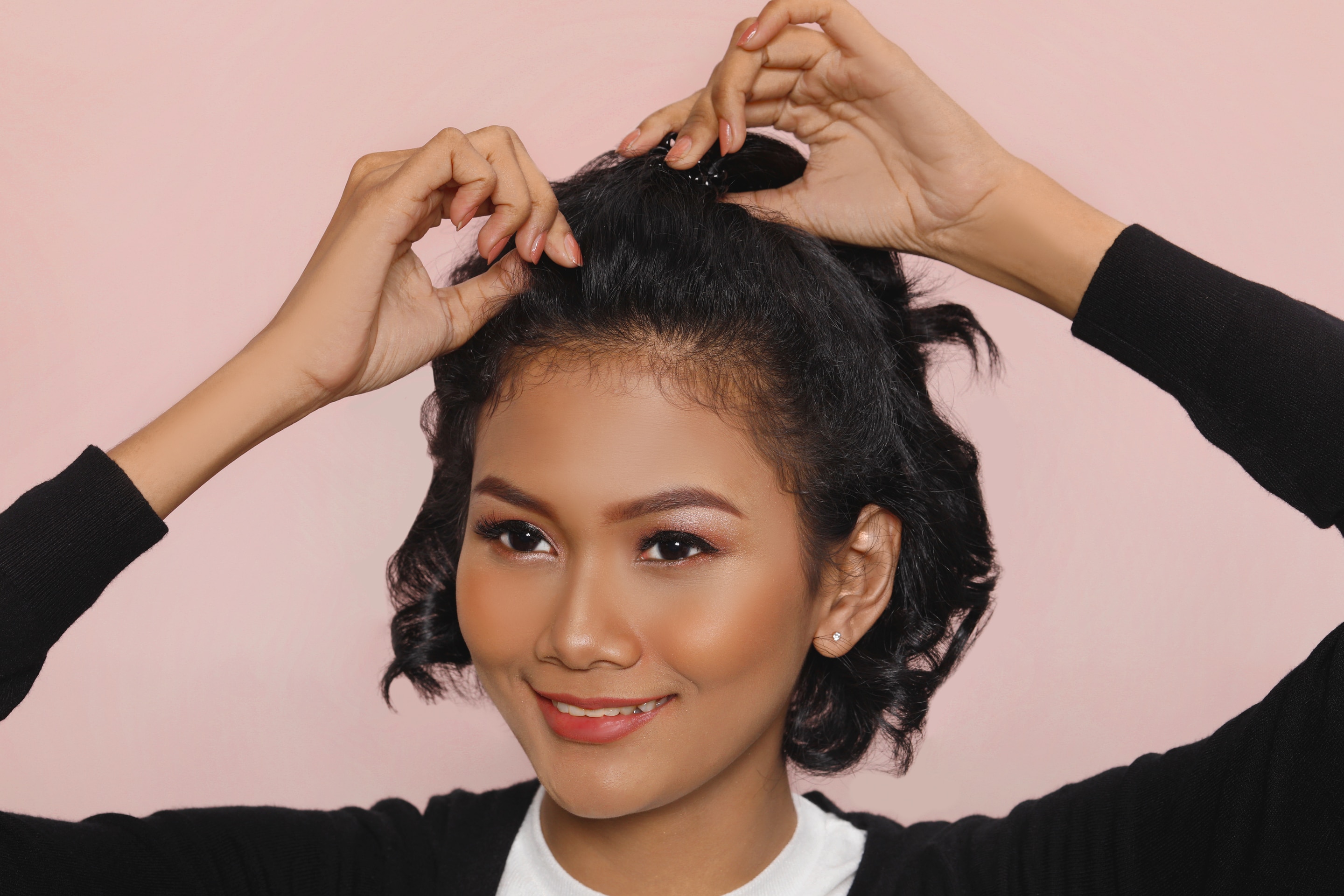 ผู้หญิงเอเชีย ผมหยิกสั้น กำลังดึงผมให้มีวอลลุ่ม