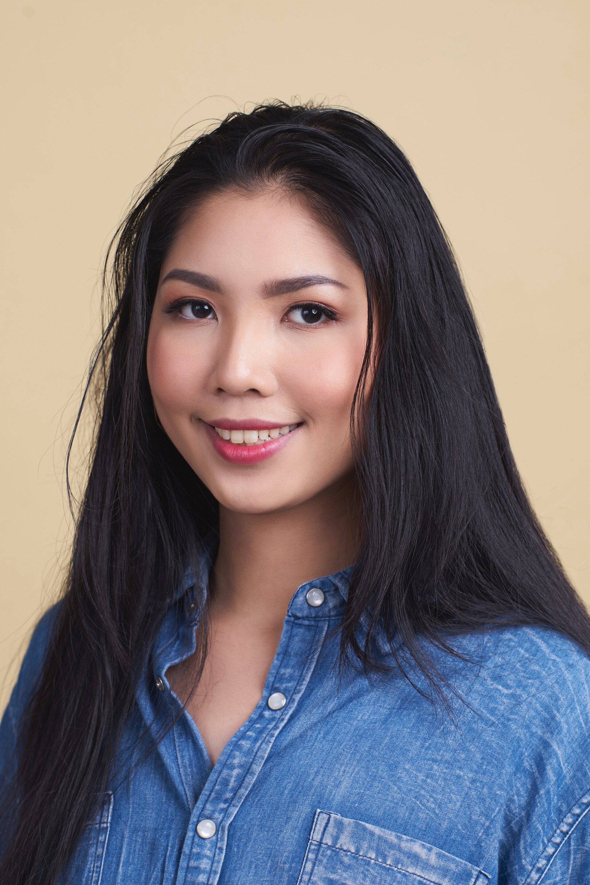 Wanita asia dengan rambut panjang dan hitam menata rambut berminyak.