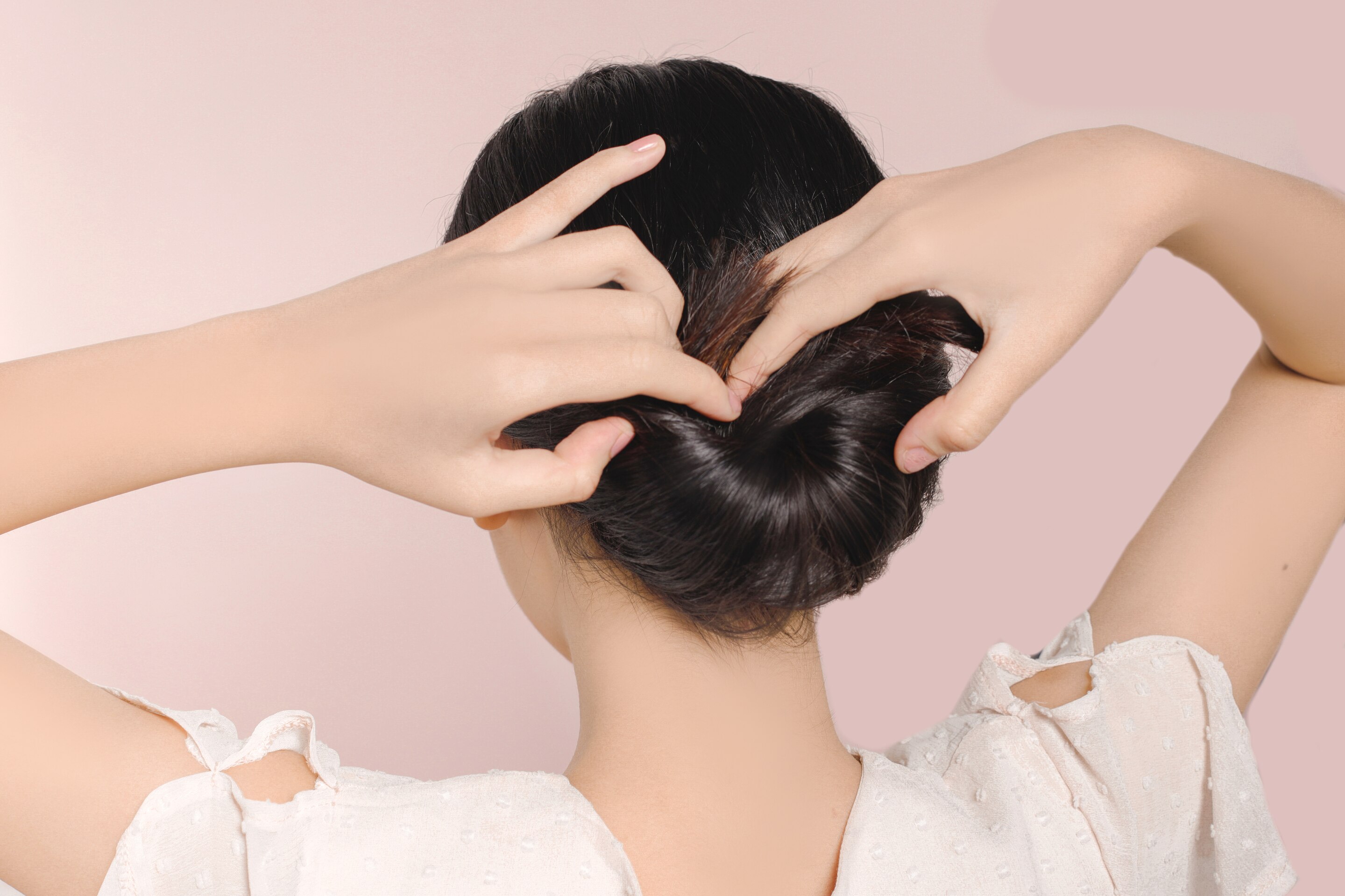 ผู้หญิงเอเชียหันหลัง ผมยาวสีดำ กำลังเกล้าผม