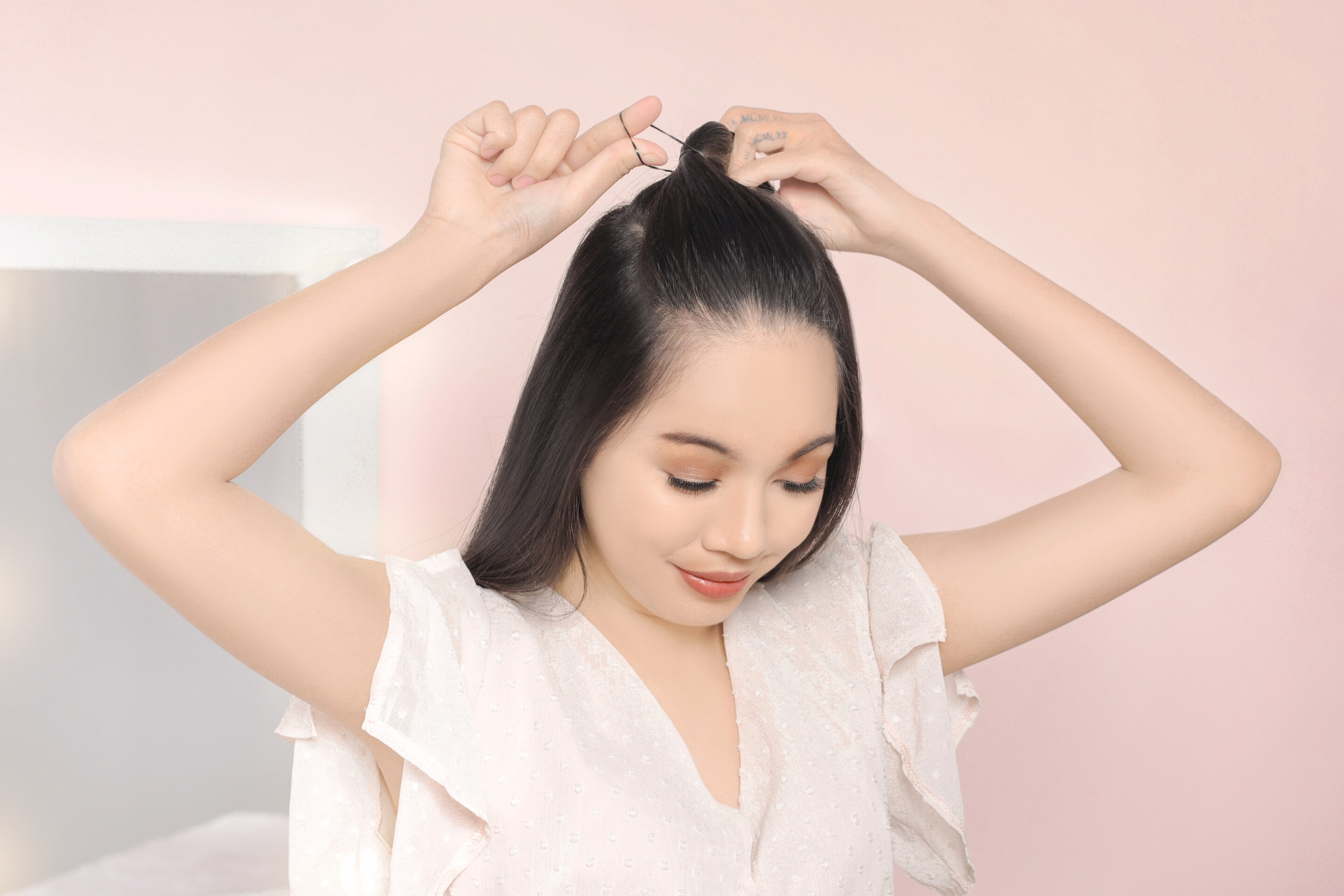 ผู้หญิงเอเชีย หันหน้า ผมยาวสีดำ กำลังมัดผมบัน