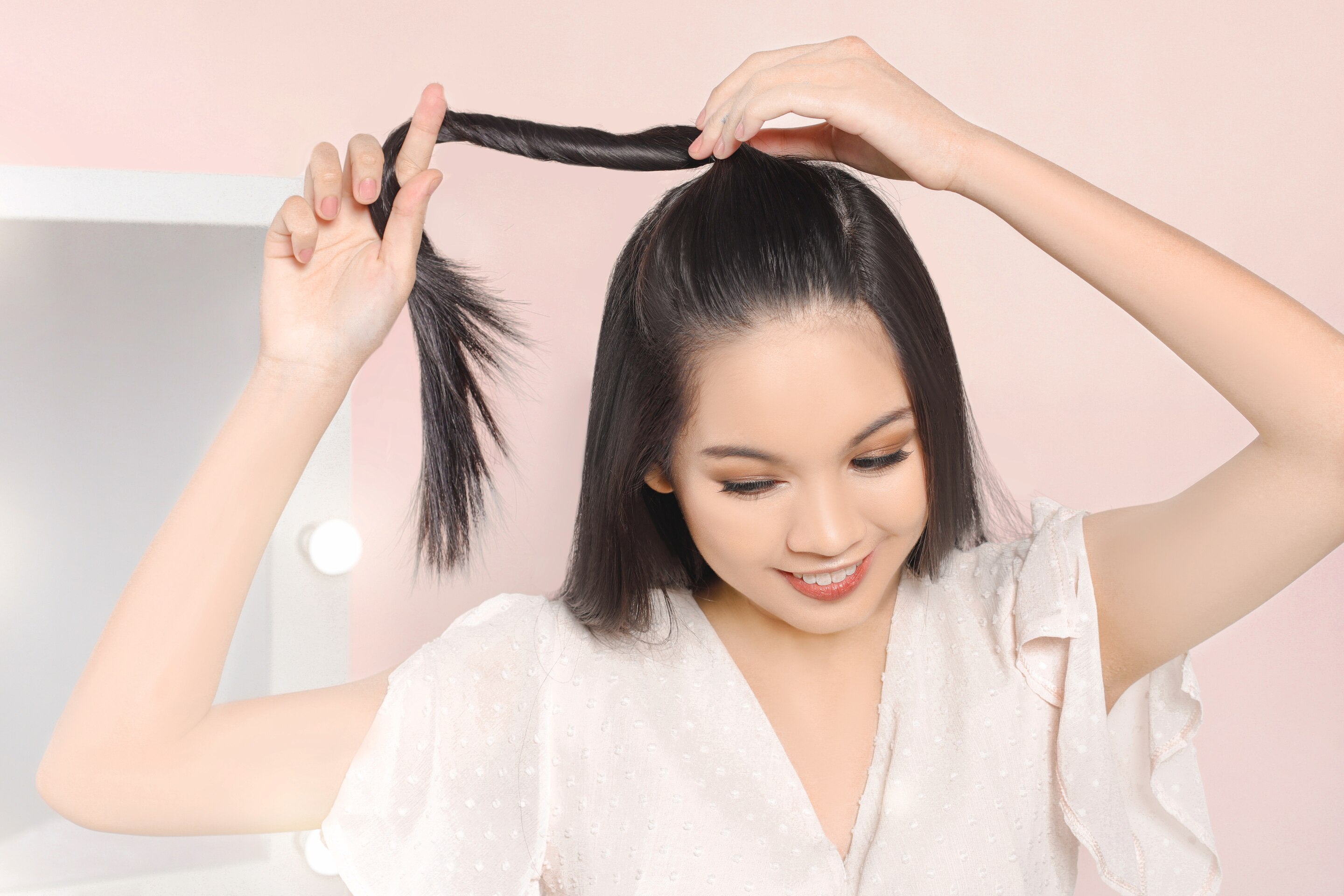 ผู้หญิงเอเชีย ผมยาวสีดำ กำลังบิดเกลียวผม