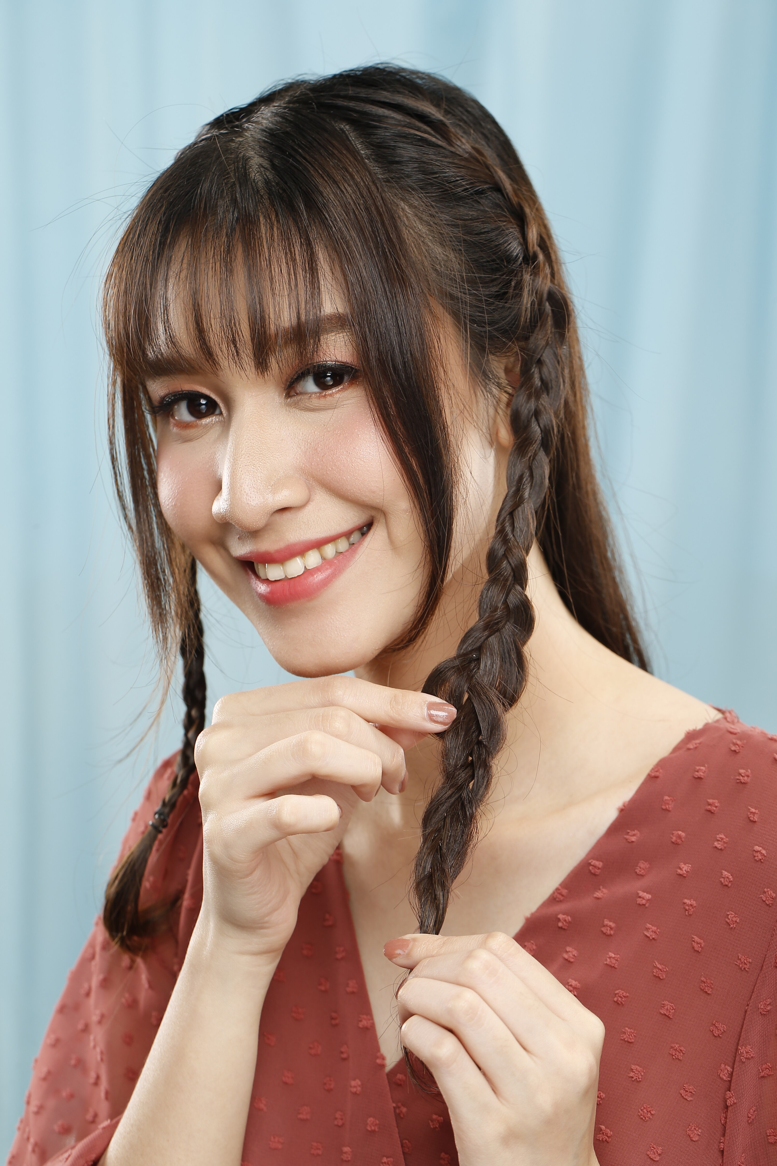 ผู้หญิงเอเชียผมยาวสีดำ กำลังถักเปีย