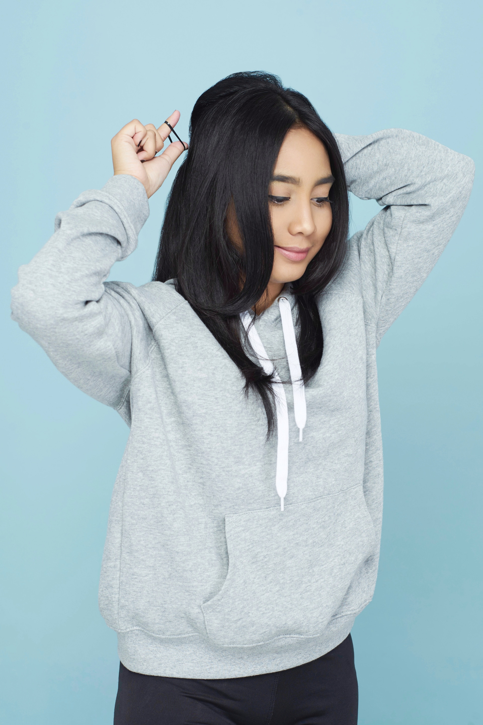 Wanita asia dengan rambut hitam sedang menata cepol half updo