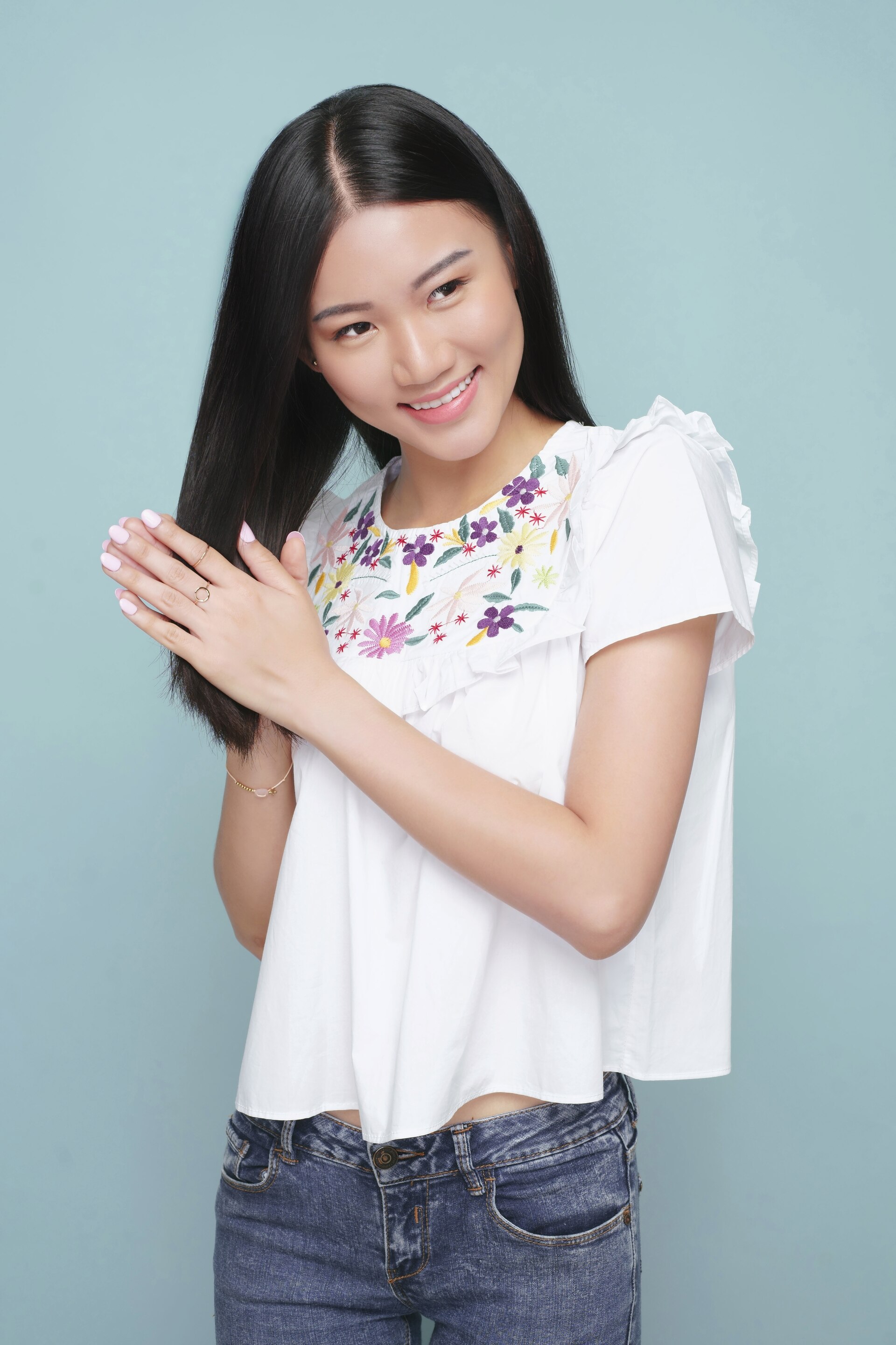 Wanita Asia dengan rambut panjang lurus sedang memakai vitamin rambut