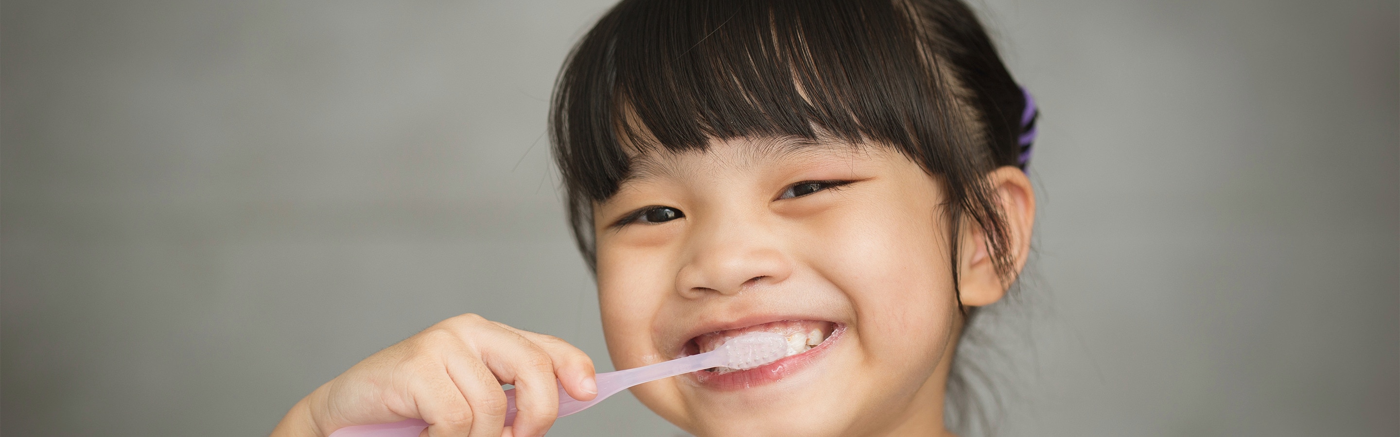 Cô gái trẻ đánh răng bằng bàn chải trước gương để tránh sâu răng