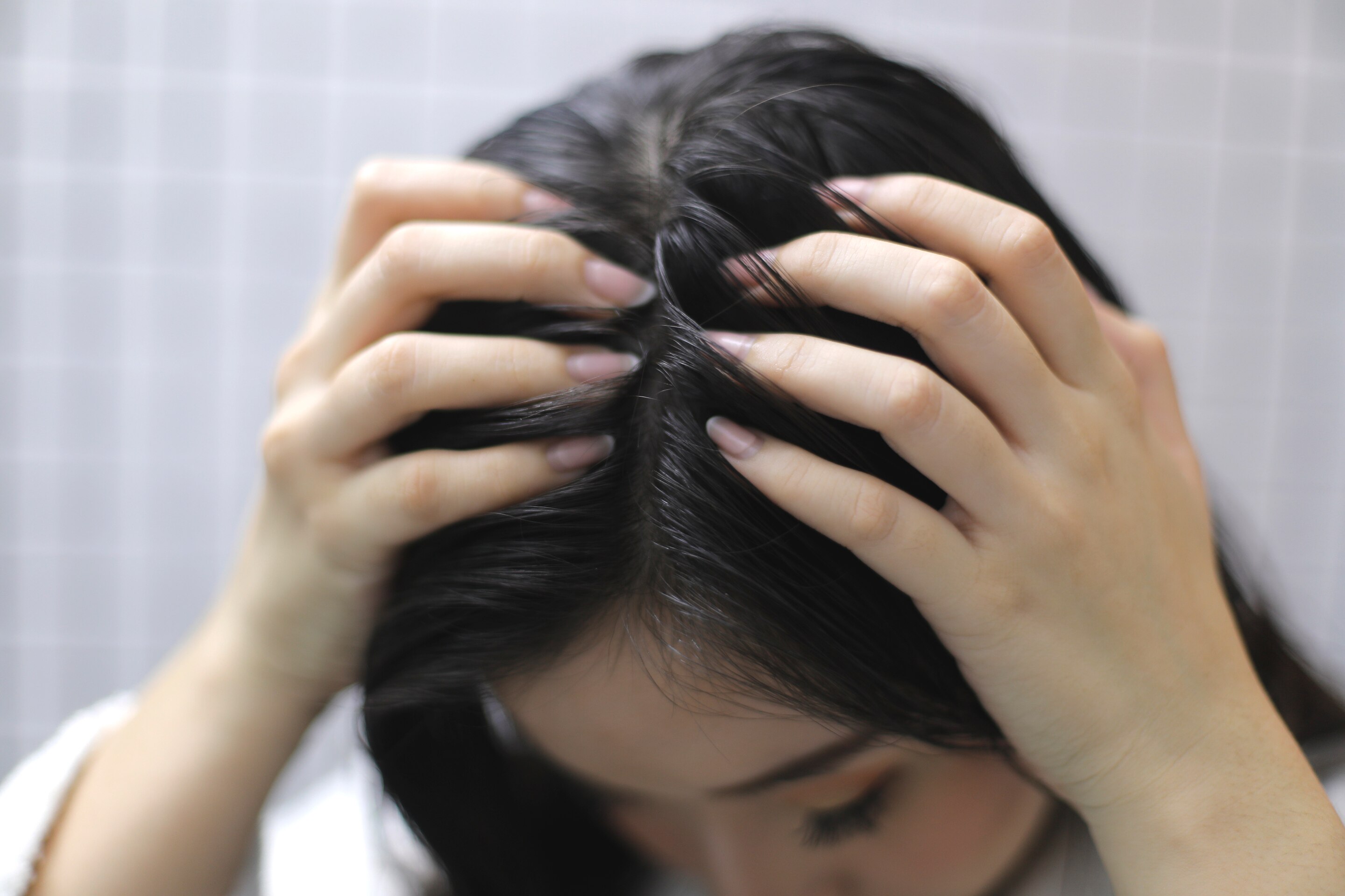 ผู้หญิงเอเชียผมยาวสีดำ กำลังนวดหนังศีรษะ