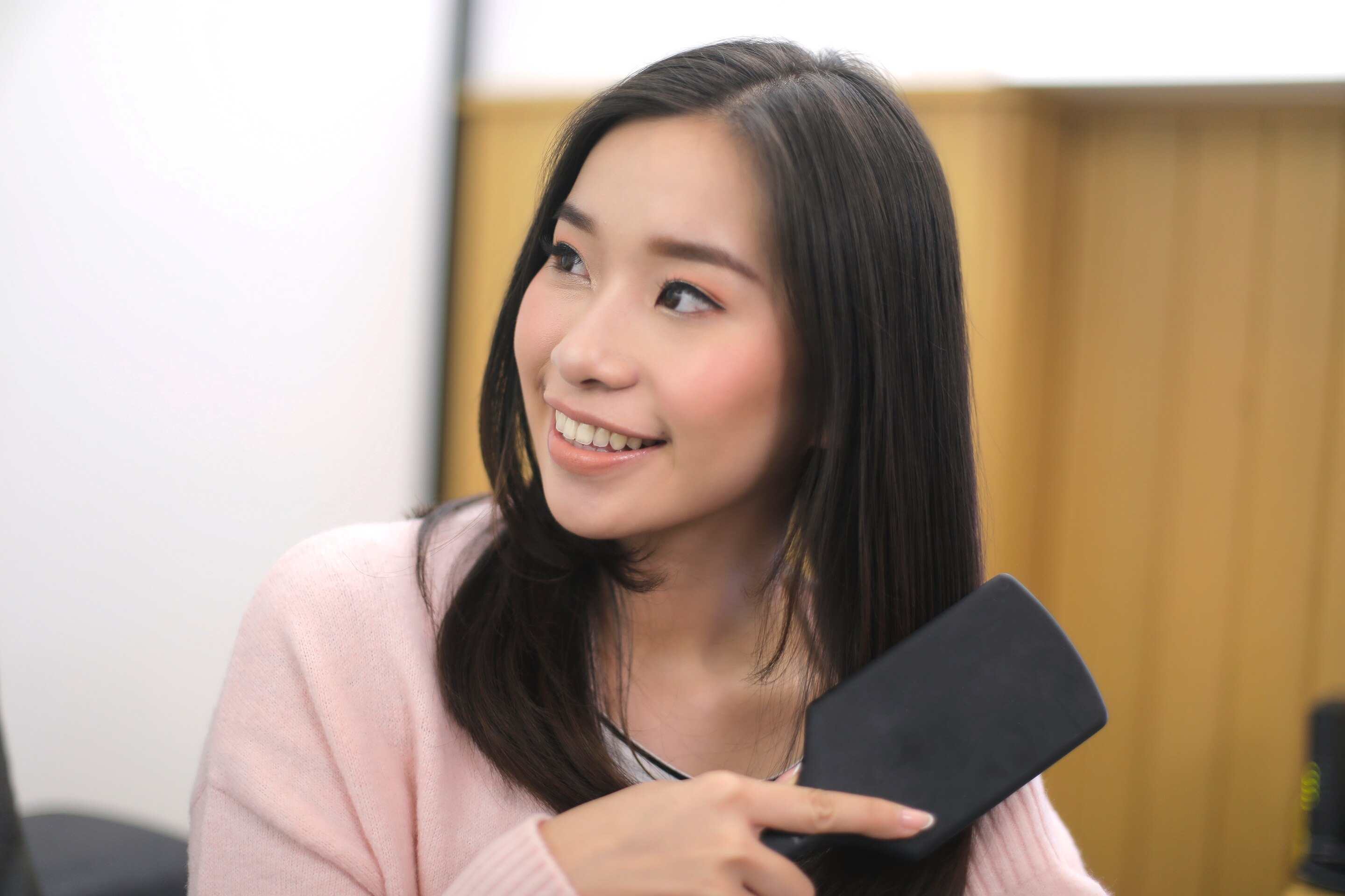 ผู้หญิงเอเชียผมยาวสีดำ กำลังแปรงผม