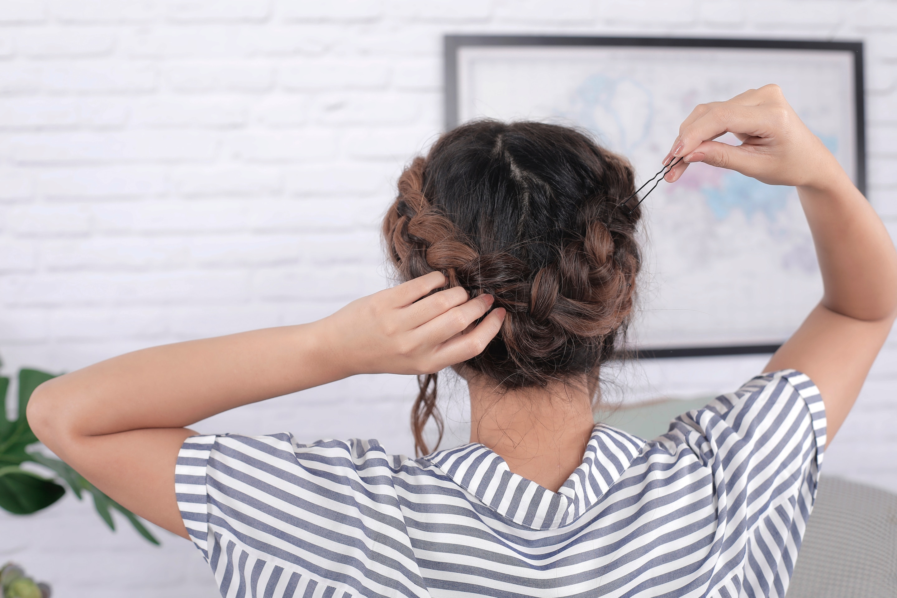 ผู้หญิงเอเชียผมยาว กำลังถักเปียรอบหัว