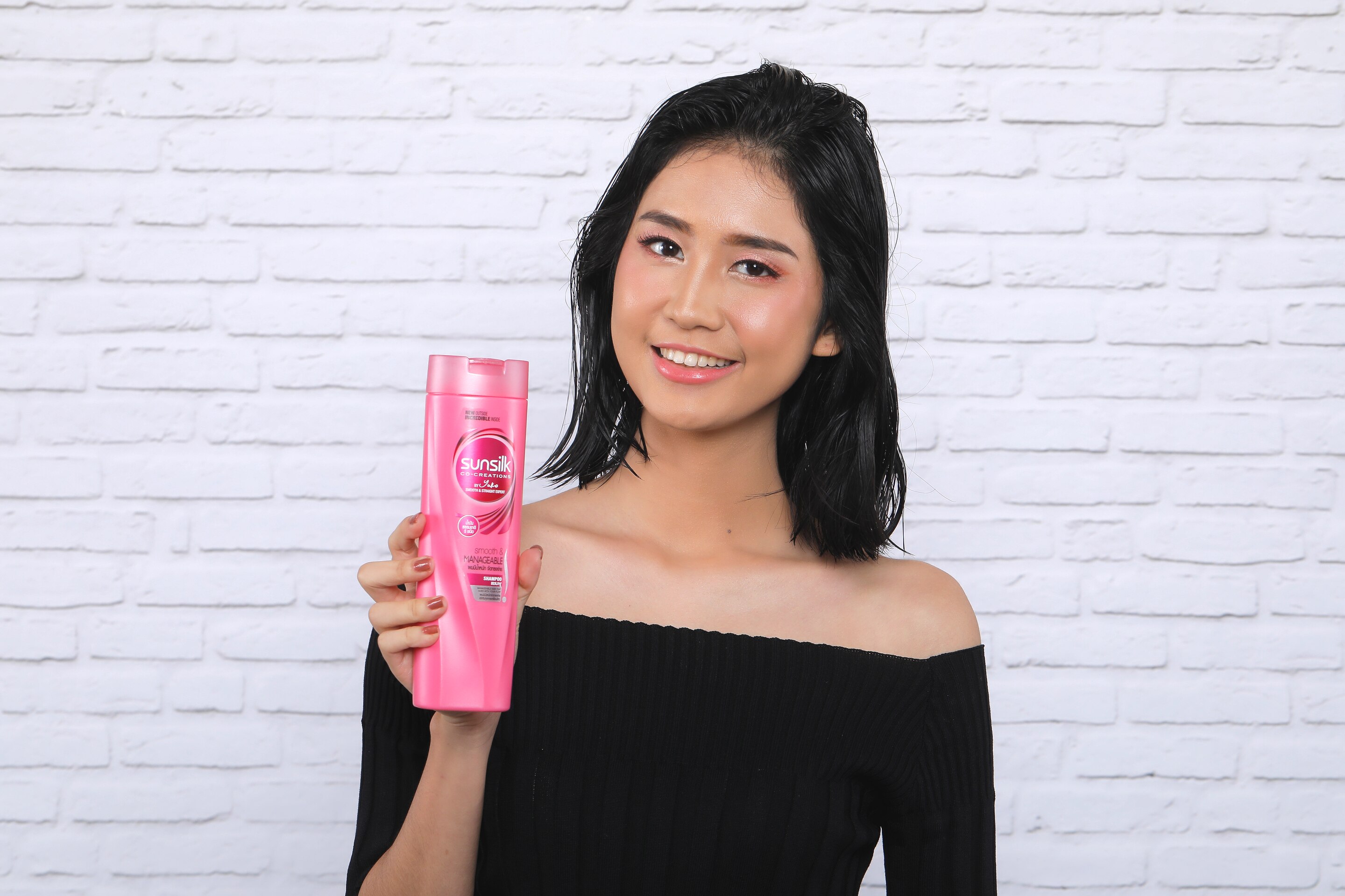 ผู้หญิงเอเชียผมสั้นกำลังถือขวดแชมพู สาธิต วิธีเกล้าผมสั้น