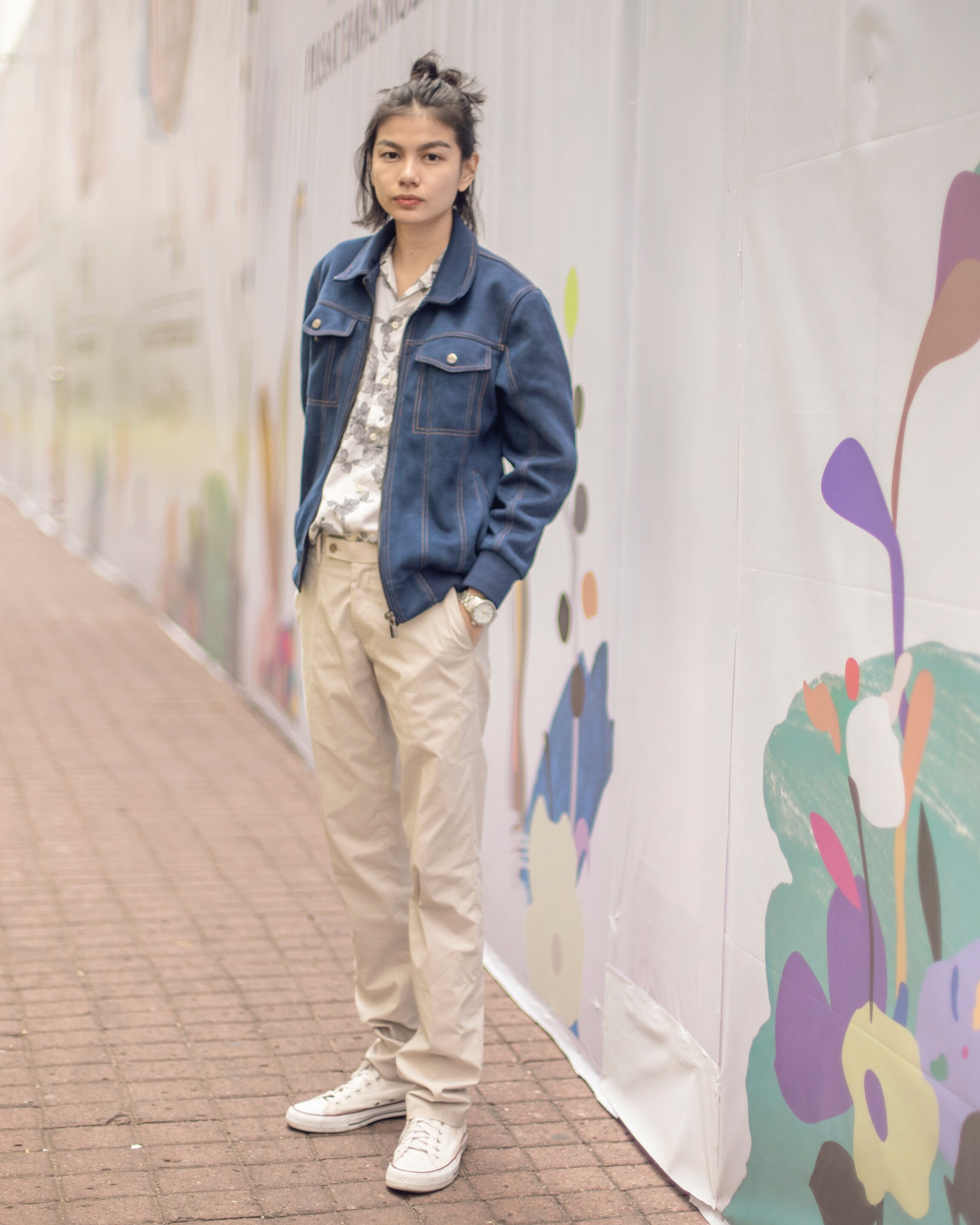 Wanita asia dengan rambut hitam sebahu menggunakan gaya rambut top knot messy