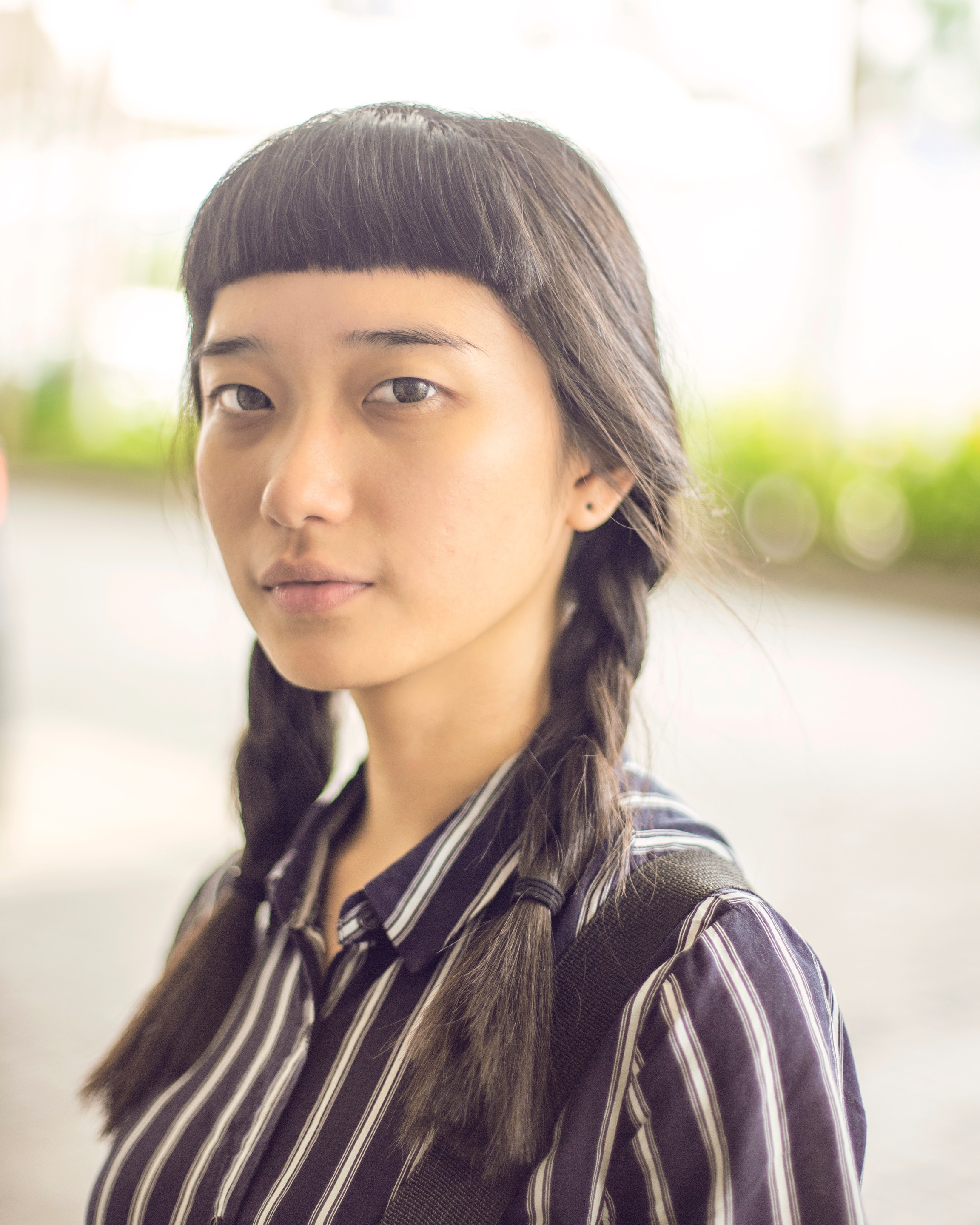 Wanita Asia dengan rambut kepang dua dan micro bangs.