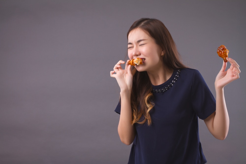 wanita memakan ayam goreng