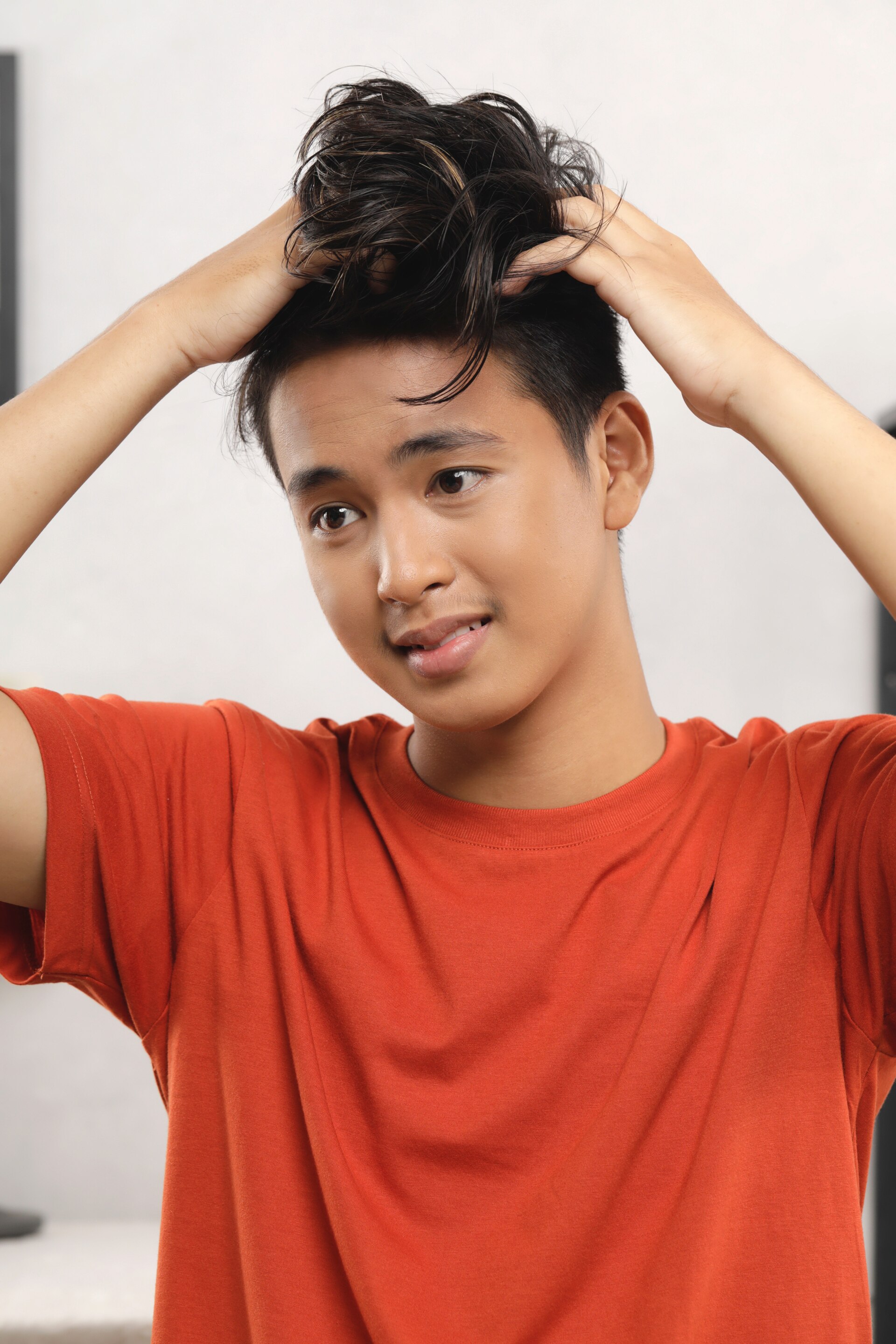 Pria asia membuat gaya messy quiff pada rambut