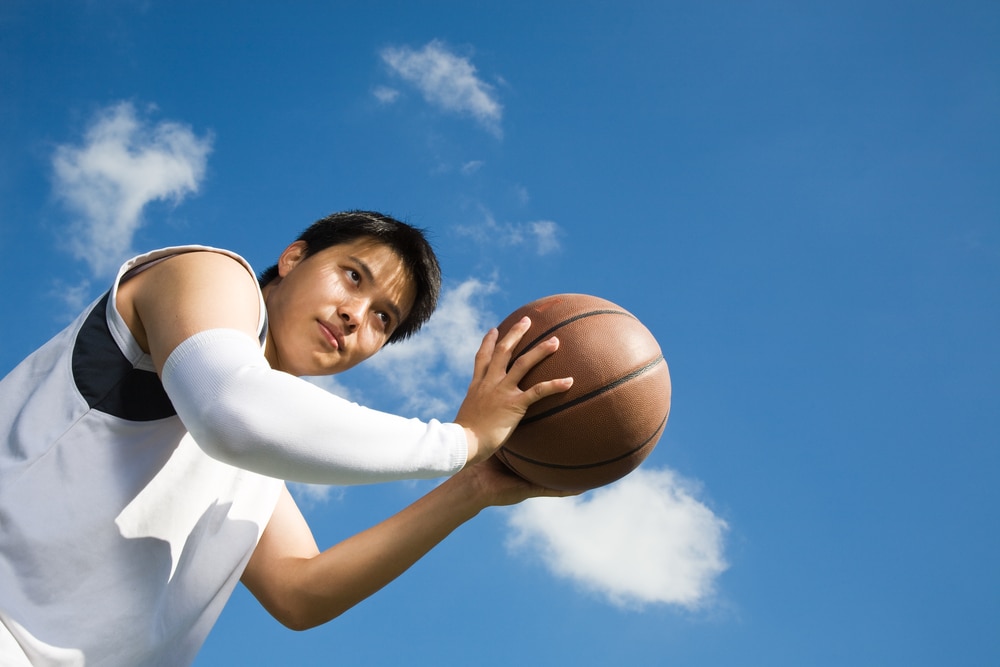 remaja pria asia sedang bermain basket