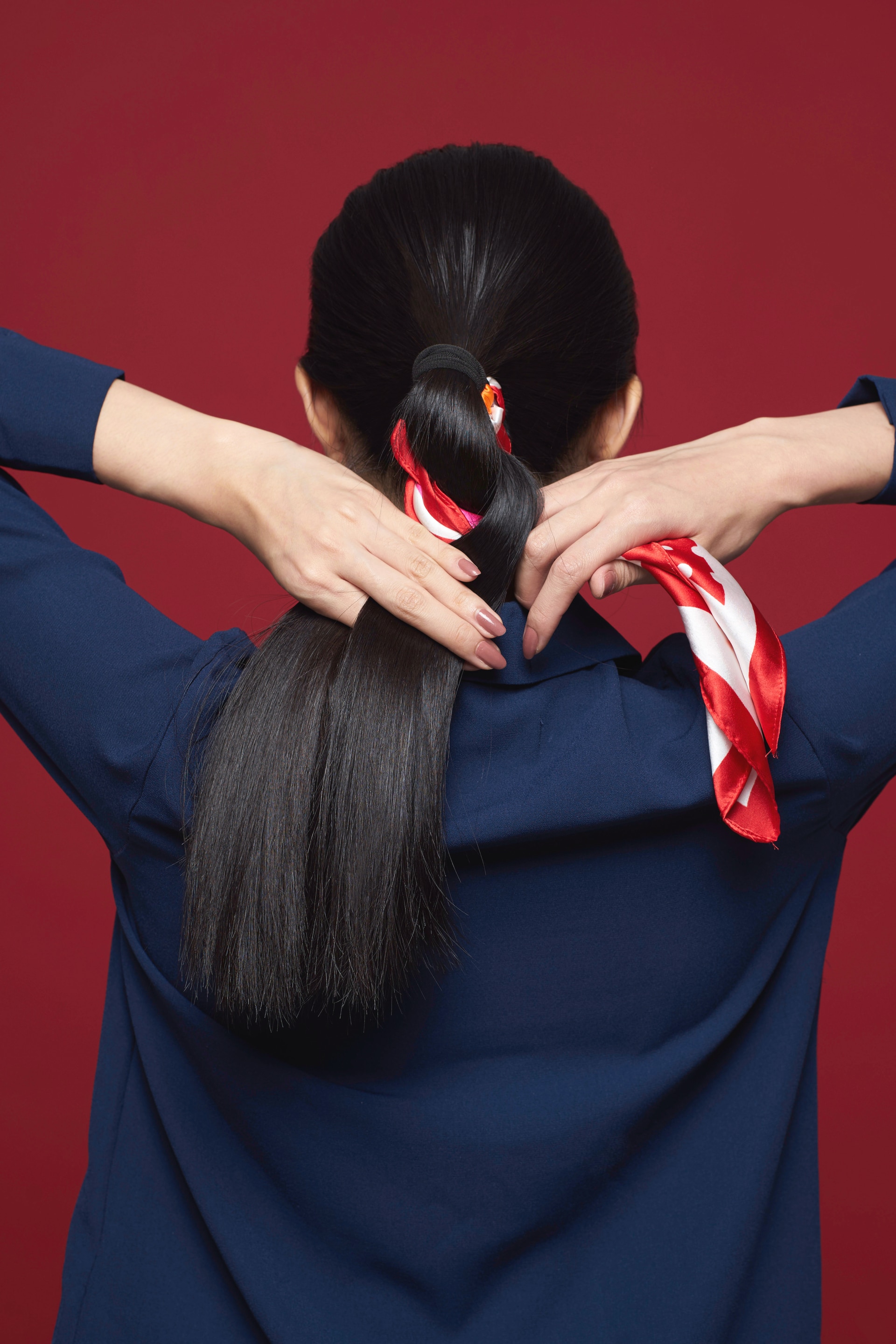 Wanita asia sedang mengepang scarf rambut – cara menata scarf rambut