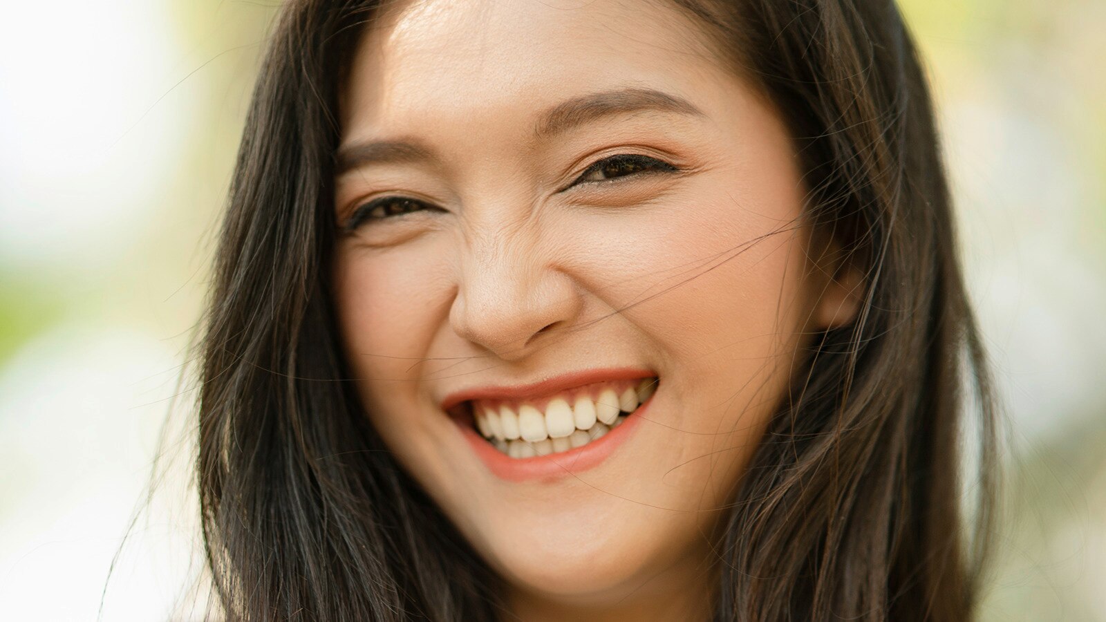 Người phụ nữ trẻ có răng trắng cười trước ống kính