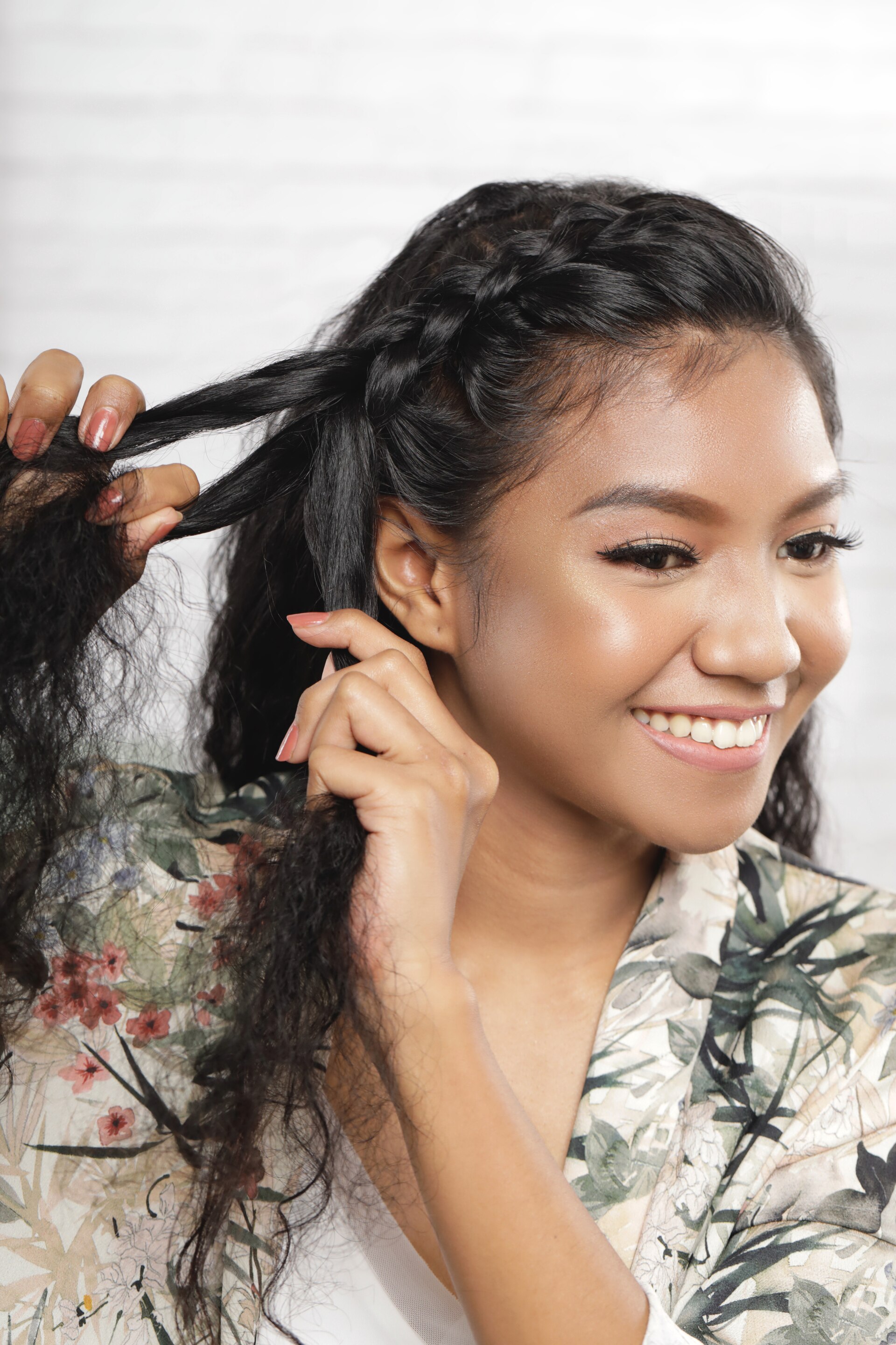 ผู้หญิงเอเชีย ไว้ผมยาวหยิก สีดำ กำลังถักเปีย