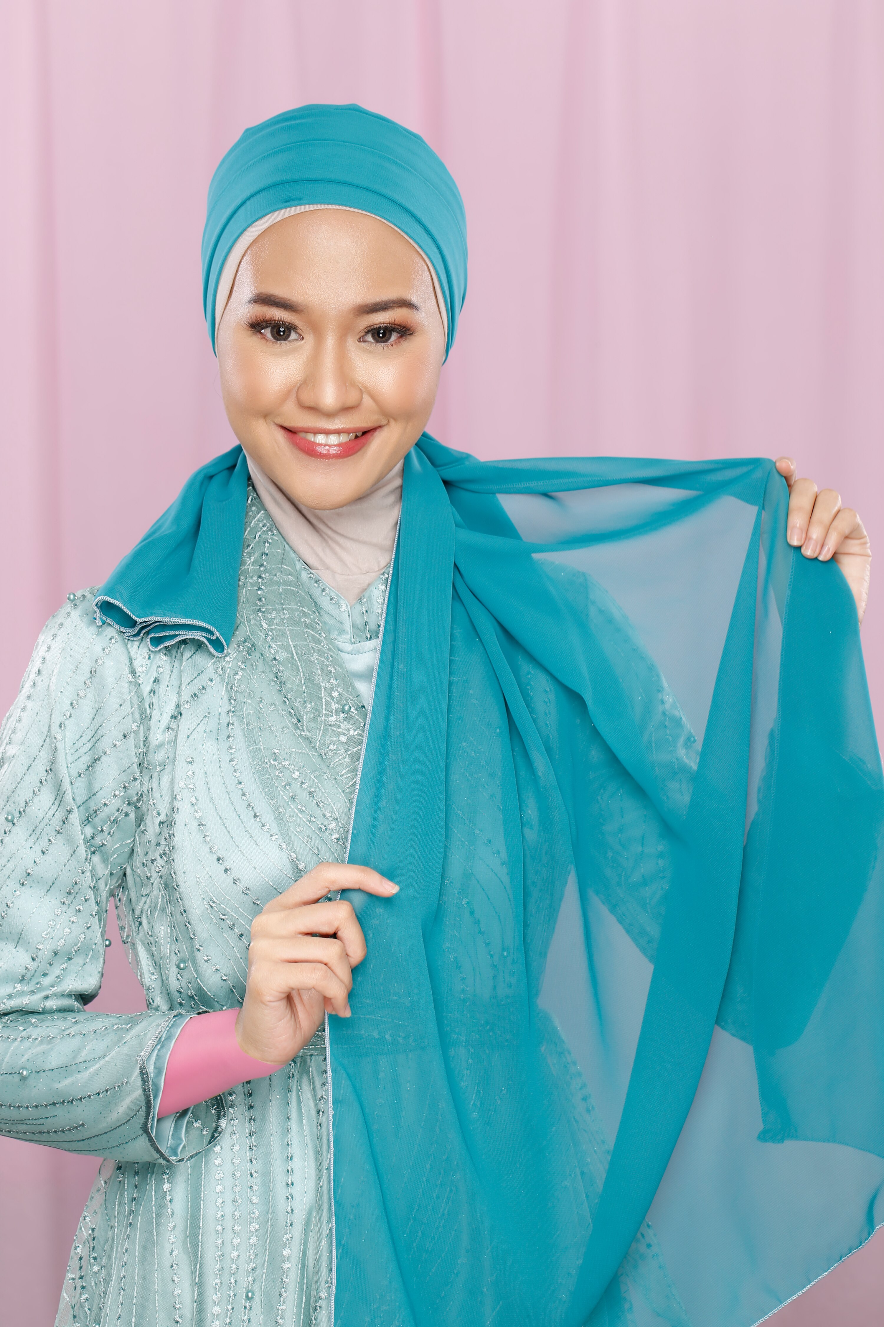 Wanita memperlihatkan tutorial hijab pesta.
