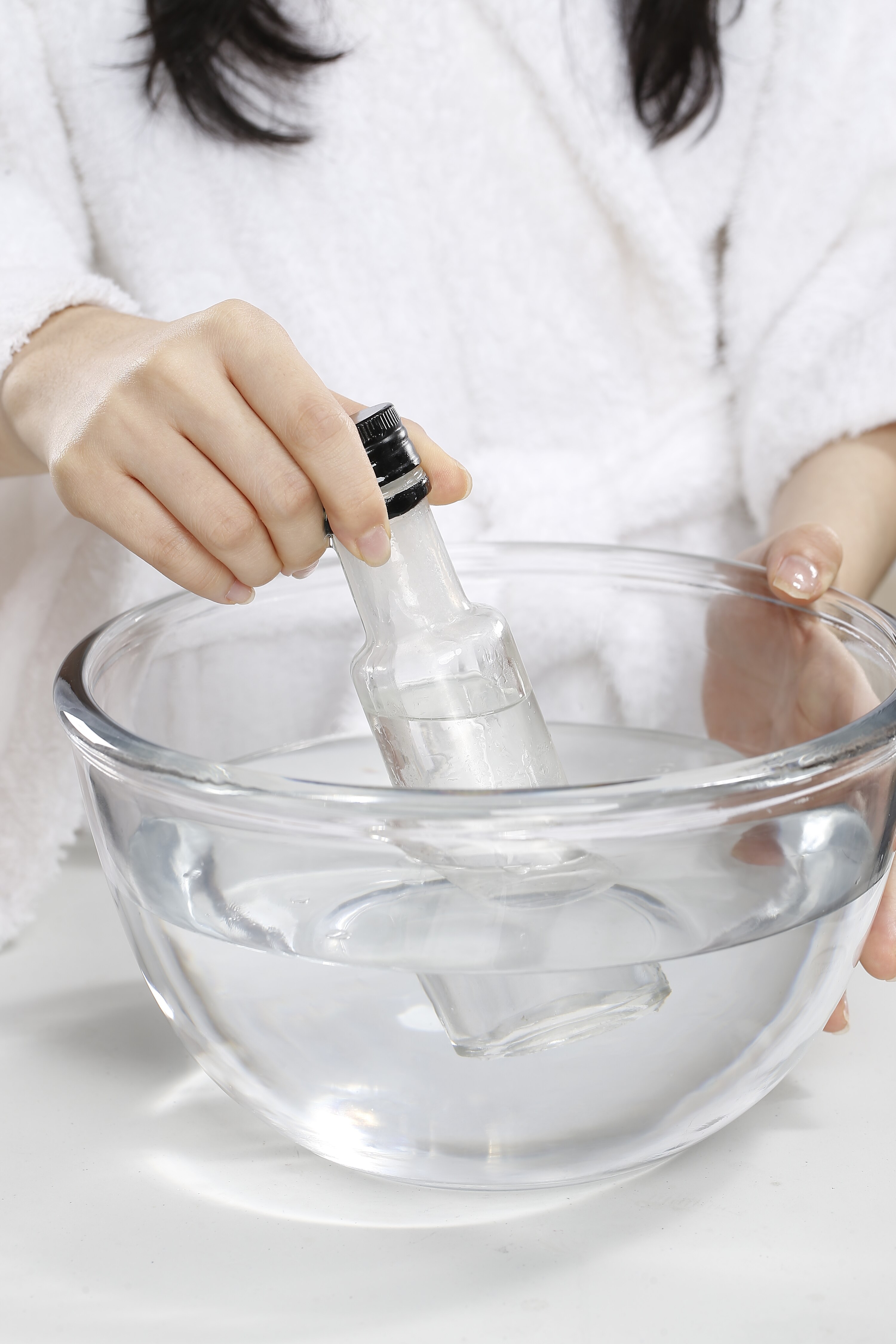 Menghangatkan minyak kelapa dalam botol air hangat