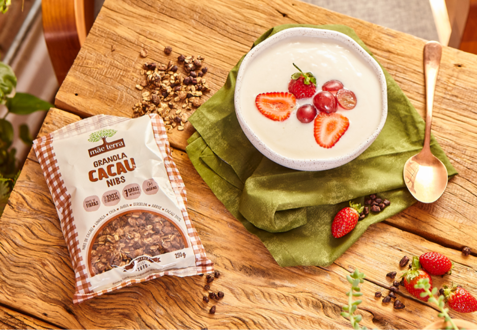Tigela com creme e frutas vermelhas ao lado da Granola Cacau Nibs Mãe Terra