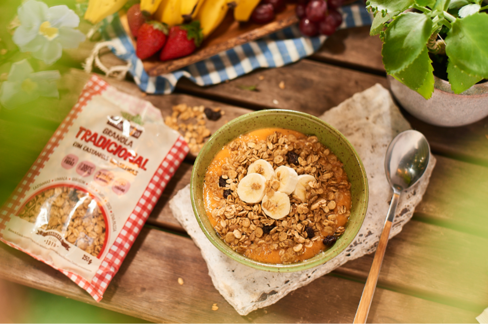 Mesa de café da manhã com a embalagem da Granola Tradicional Mãe Terra aberta