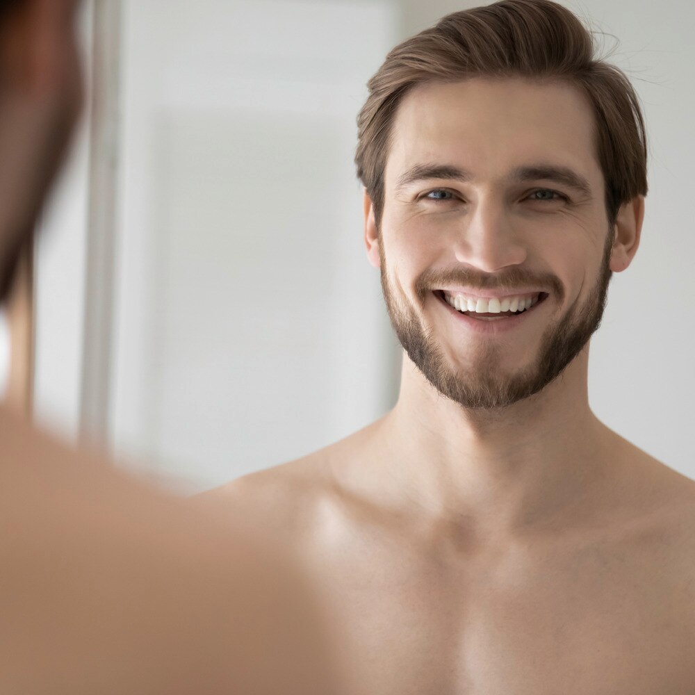 Man looking in the mirror and smiling