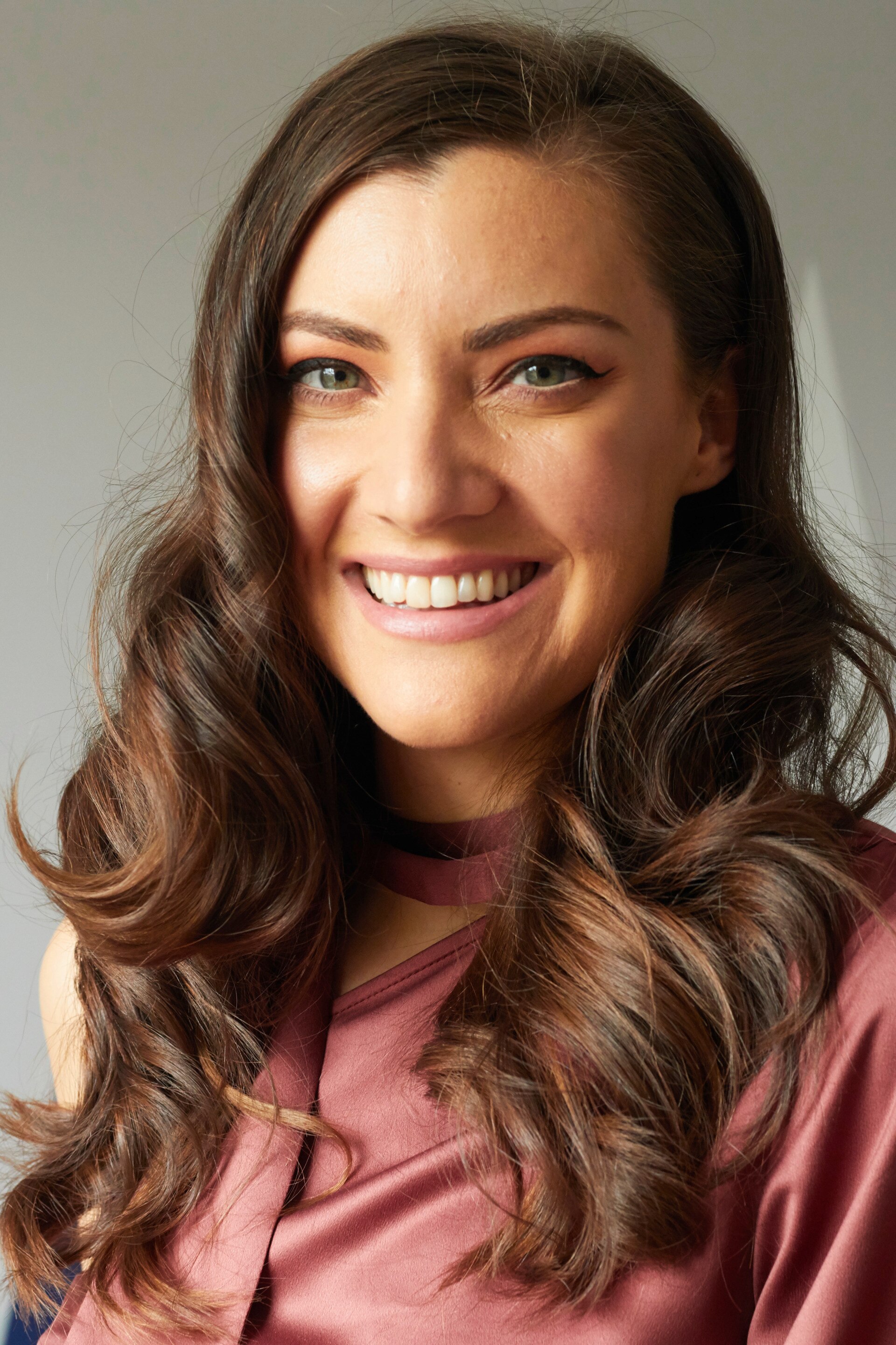 Woman with dark brown hair with golden blonde highlights around face-framing