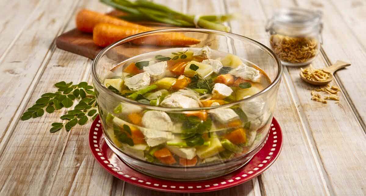 Sup ayam dengan daun kelor disajikan dalam panci kaca