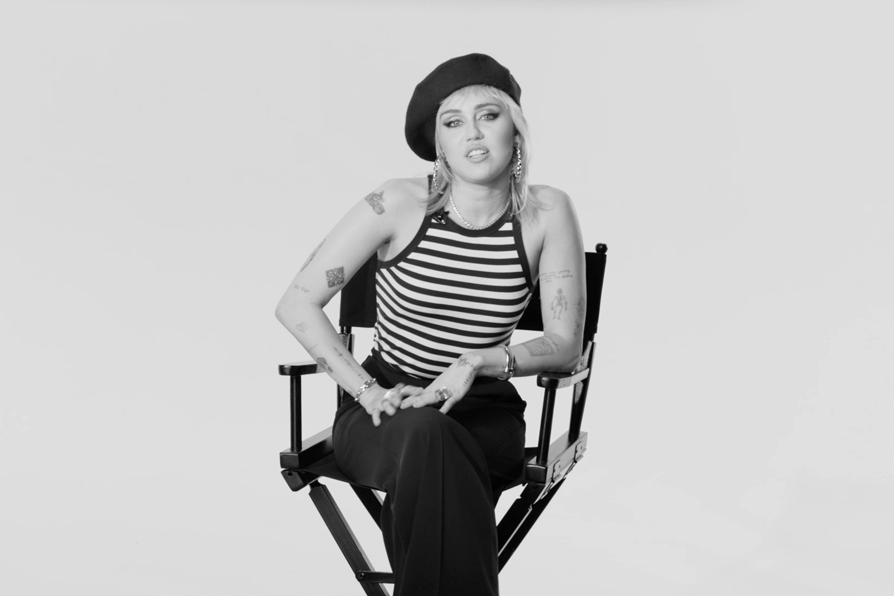 Miley Cyrus being interviewed sat on a director's chair for Magnum