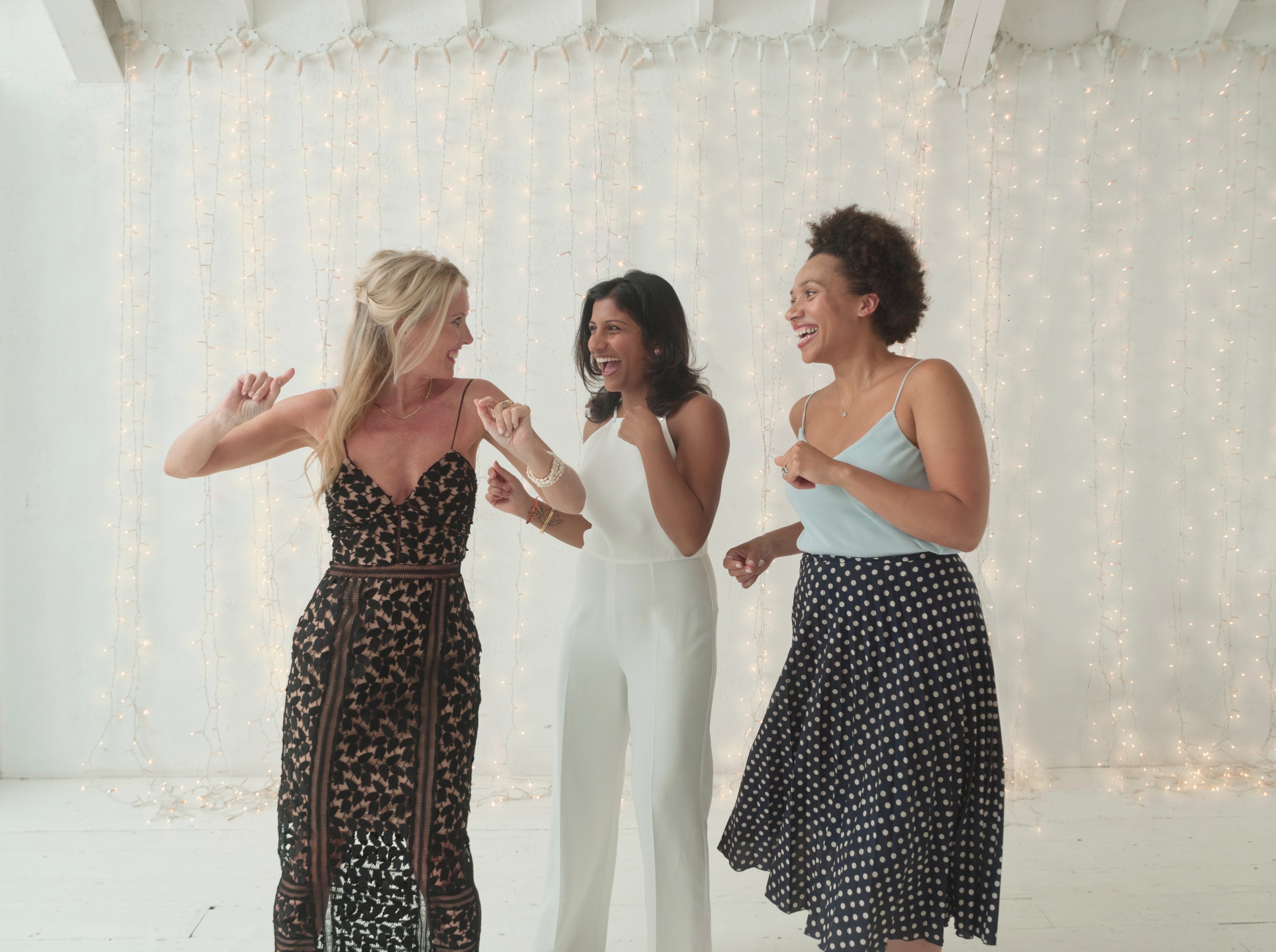 Tres mujeres de diferentes etnias bailando felices juntas