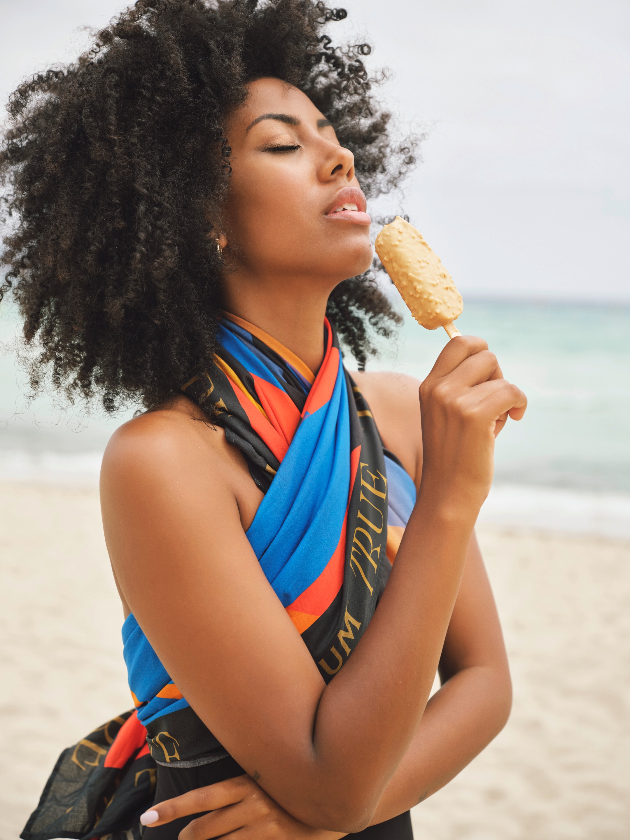 Model wearing a magnum sarong as a top while eating a Magnum ice cream