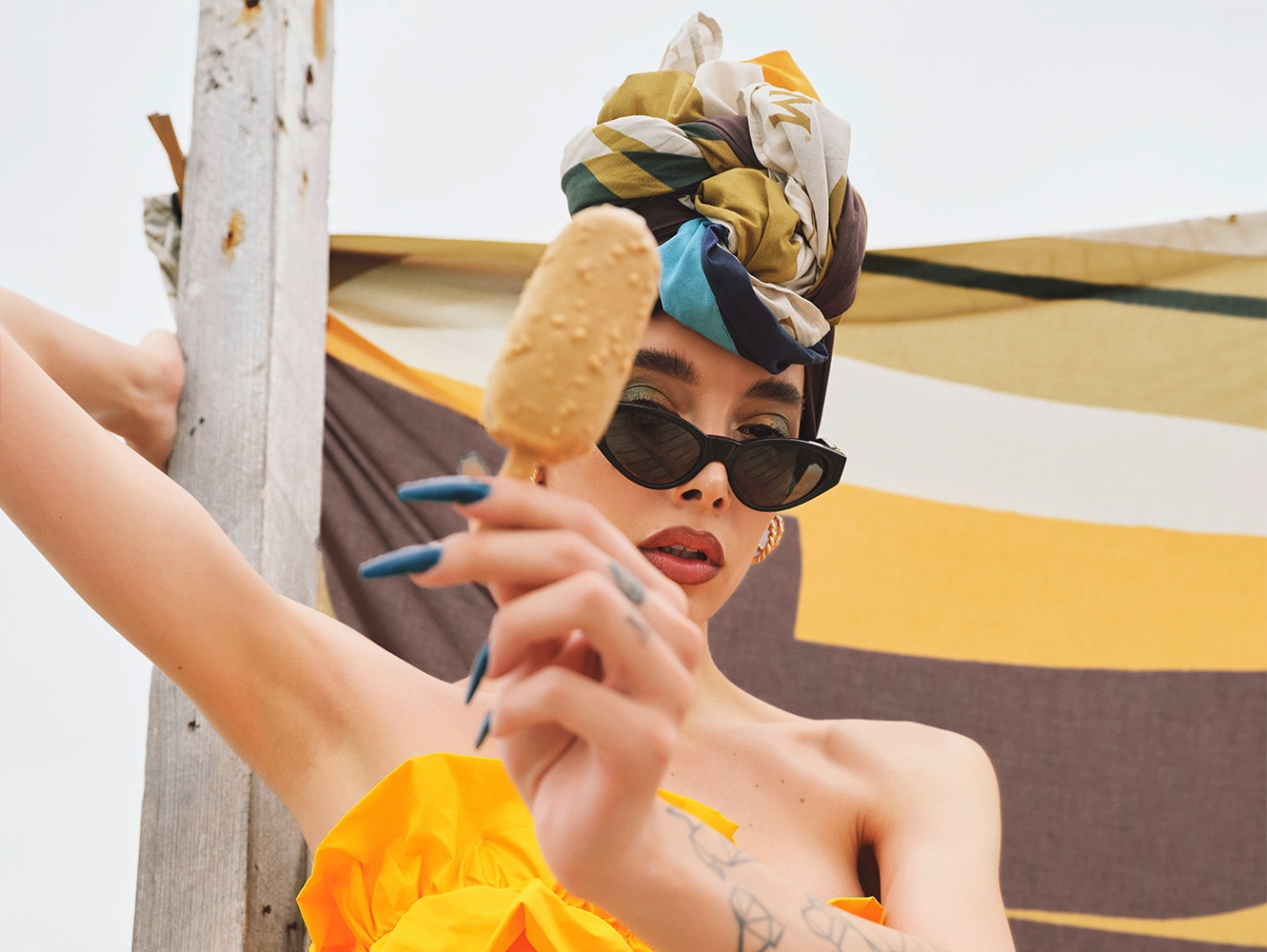Model holding a magnum ice cream with a Magnum towel floating behind