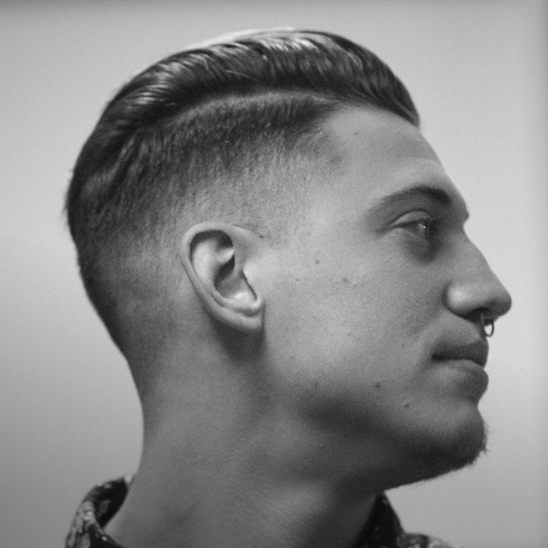 A guy with a quiff and a nose ring, in profile.