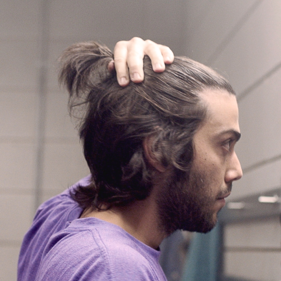 A guy with a man bun, in profile.	