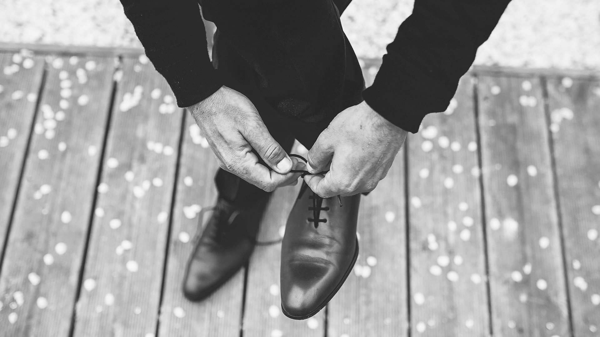 Un hombre atando los cordones de sus zapatos de vestir.