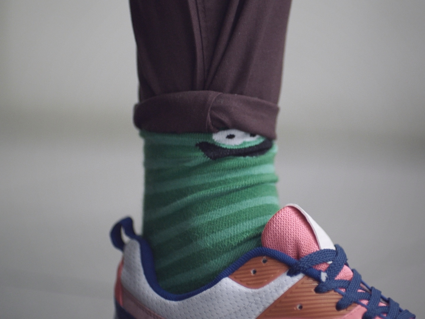 A guy in brightly colored socks and sneakers, with cuffed pants.