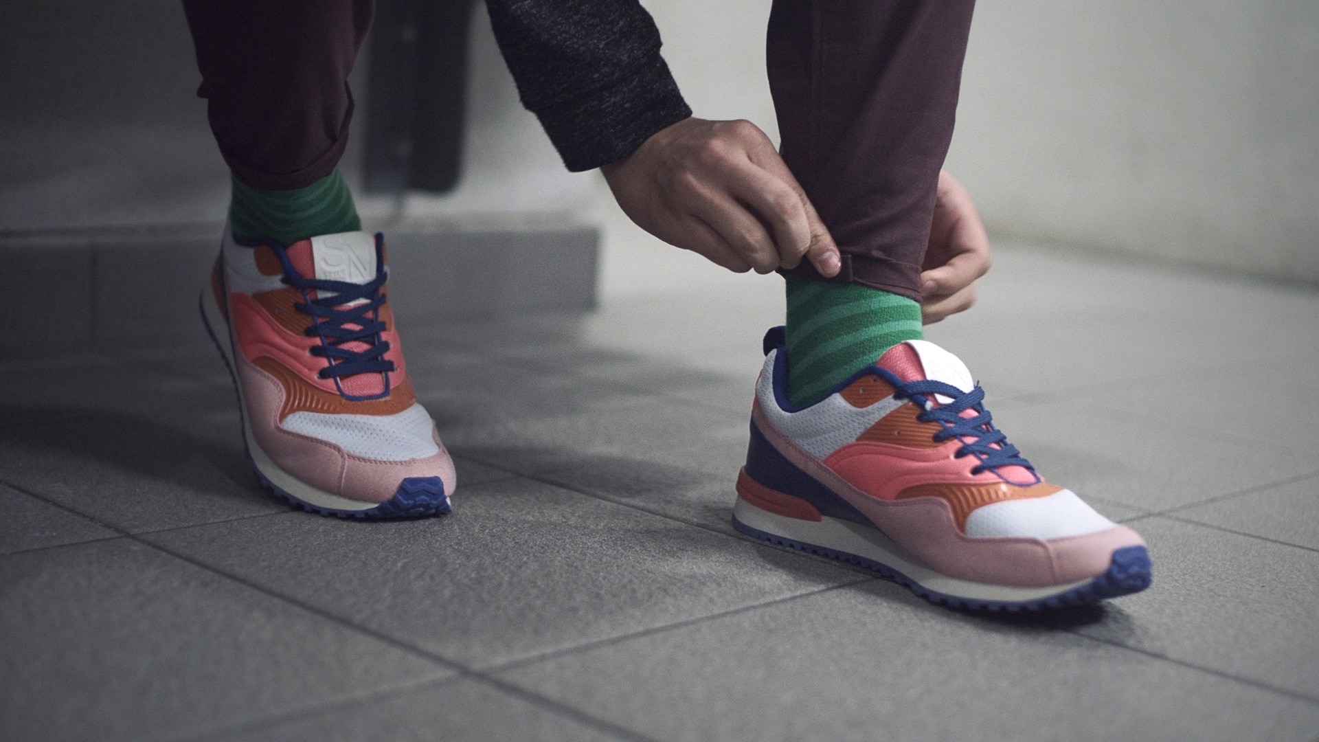 A guy in brightly coloured trainers.	